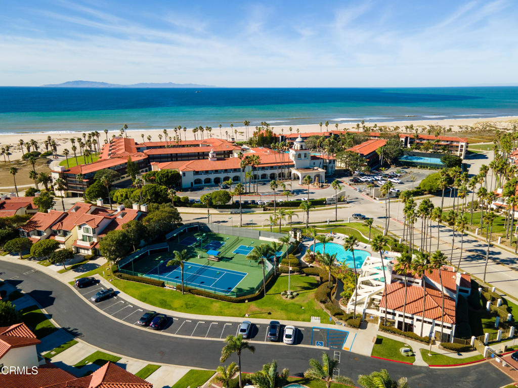 Welcome to your own slice of paradise at The Colony -- one of Oxnard's premier gated, resort-style communities located just across from some of Ventura County's most scenic beaches. This light-filled 2-bedroom, 2-bath condo features an open floor plan, high ceilings, and a romantic spiral staircase leading to a spacious loft--perfect for a home office, guest space, or entertainment room.Enjoy peek-a-boo harbor views from the balcony and primary suite, plus the serenity of lush, well-maintained landscaping surrounding this private location. The kitchen opens to the dining area and living room with a cozy fireplace and adjacent den or reading nook. Bedrooms are thoughtfully positioned on opposite sides of the unit for added privacy, and both full bathrooms are generously sized.Expansive balcony offers extra outdoor living space, and the 2-car garage is conveniently located with plenty of room for storage. The Colony offers unmatched amenities: two sparkling pools, multiple spas, a fitness center, tennis and pickleball courts, a beautiful clubhouse, and 24-hour gated security.Ideally situated near Channel Islands Harbor, the Mandalay Beach Resort, and halfway between Malibu and Santa Barbara--you'll enjoy beach walks, boating, dining, shopping, and more. Coastal living doesn't get better than this!