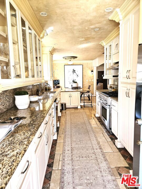 A new price and a new look!!! Welcome to a stunning architectural gem nestled in the heart of Larchmont Village. This exquisite residence showcases the timeless elegance of Spanish Colonial Revival architecture, seamlessly blending historical charm with modern amenities. This property comes with 3 bedrooms & 2 baths in the main house with an attached home office leading to the living room, a newly landscaped front yard with automatic sprinklers, whisper-quiet central heating & air newly installed in the main house & home office, an electric fireplace, and cathedral ceiling in the living room. High ceilings in the full guest house feature brand-new kitchen appliances. Laundry room with garage access has a new washer & dryer. Beautifully designed cozy backyard. All rooms including the 4 bedrooms between the main house and guest house have been professionally staged by a designer. A home that effortlessly blends elegance, comfort, and thoughtful design sure to impress even the most discerning buyer.