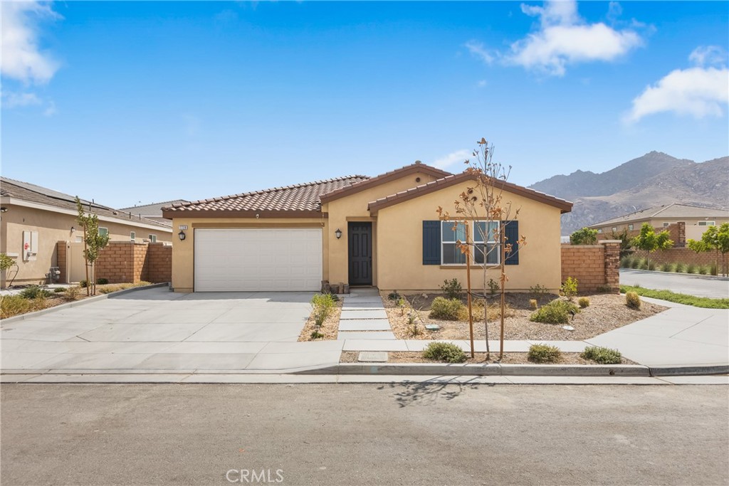 Welcome to this beautiful single-story home in the desirable Spring Mountain Ranch community of Riverside. Built in 2023, this residence offers comfort, style, and thoughtful builder upgrades throughout. Step inside to an inviting open-concept floor plan featuring 4 spacious bedrooms, 2 bathrooms, and approx. 2,106 sq ft of living space. The kitchen boasts a large center island, upgraded quartz countertops, upgraded flooring, and premium cabinetry, opening seamlessly to the dining and living areas — perfect for both everyday living and entertaining. Additional touches like recessed lighting add warmth and style throughout. The primary suite offers an oversized bedroom with plenty of space to relax and unwind, along with a well-appointed ensuite bath, creating the perfect retreat. Set on a 7,405 sq ft corner lot in a quiet cul-de-sac, the property has been enhanced with an extended concrete driveway for additional parking and a backyard concrete patio, offering an ideal setting for outdoor relaxation and gatherings. Living here means enjoying the best of the Spring Mountain Ranch lifestyle — surrounded by scenic mountain views, with community parks, playgrounds, and hiking/biking trails just steps away. Commuters will also love the convenient access to freeways, UC Riverside, shopping, and dining. With its builder upgrades, energy efficiency, and move-in ready condition, this home gives you all the benefits of a newer build without the wait. Its spacious layout, prime location, and community amenities make it the perfect blend of comfort, convenience, and value.