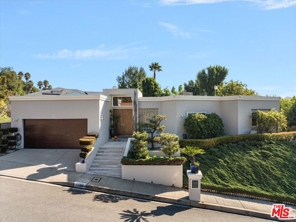 Set on a peaceful street just off the coveted Benedict Canyon, this stylish and updated single-story contemporary home offers the perfect blend of modern living and serene privacy. Located just minutes from Beverly Hills' world-class shopping and dining, this property combines convenience with a tranquil retreat. Bright and airy, the home features beautifully refinished parquet hardwood floors, a newly updated kitchen with sleek countertops, and stainless steel appliances. The open floor plan includes a formal living room, dining area, and breakfast bar, all enhanced by recessed lighting for a warm, inviting ambiance. Surrounded by lush greenery, the backyard serves as a private oasis, complete with a large patio ideal for entertaining and a sports court for recreation. This home delivers effortless style, comfort, and functionality in an unbeatable location.