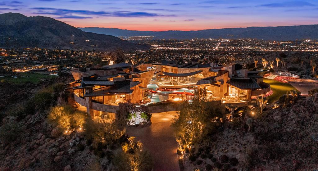One of the most spectacular estates ever built. Unparalleled in size, scale and design. Organically constructed into a summit hilltop, which can not be duplicated. Surrounded by pools of oscillating water offering staggering mountain and valley views from every room. Created by renowned architectural designer Guy Dreier and was Robb Report's Ultimate Home of the Year. Retractable walls of glass create the quintessential indoor outdoor living. Mirroring the natural terrain, the home features overlapping planes and serpentine walls forming asymmetrical pavilions. The focal point of the living room is a massive titanium-clad fireplace and ceiling of undulating wood panels. A Dale Chihuly sculpture accentuates the beauty of the room. Meander to the gracious dining room through an impressive aquarium tunnel, comprised of 2 tanks of exotic fish and a rare shark tank. The owner suite is reminiscent of the finest resorts in the world, complete with panoramic views, outdoor lounge area, private outdoor spa, fireplace and dual baths and closets. The main residence has an additional suite plus staff quarters. The guest pavilion contains four expansive bedroom suites, kitchen and lounge areas. The infamous private office is perched high into the rock and sits on a plateau with unobstructed views of the valley below. Three interlocking sculptural pools offer a one-of-a-kind swimming experience. This property has no equal. Own your own private resort within BIGHORN Golf Club.