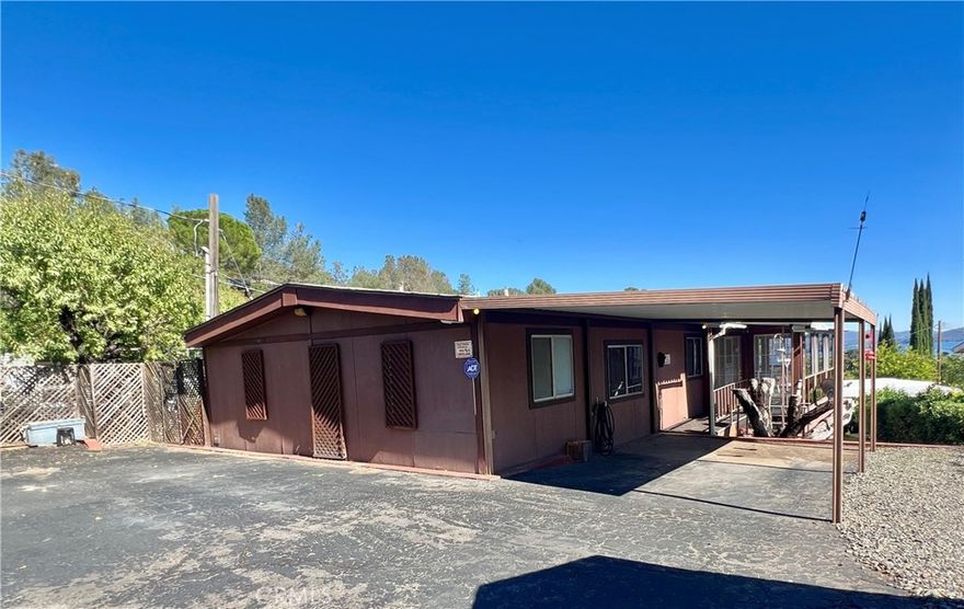 Welcome to this charming 1980 doublewide manufactured home offering 2 bedrooms and 2 bathrooms, set on a new 433A permanent foundation. The property is located in the desirable Konocti Bay area of Kelseyville, with partial views of beautiful Clear Lake. Step onto the wraparound covered deck, enclosed with glass panels—perfect for relaxing year-round. In back, you’ll find a spa where you can unwind while enjoying the peaceful surroundings.

Inside, the floor plan flows nicely between the kitchen, dining area, and living room. The all-electric kitchen features linoleum flooring, ample cupboard and pantry space, and convenient storage throughout. The living and dining areas, as well as both bedrooms, are carpeted for comfort. There’s extensive storage space beneath the deck, plus a spacious detached workshop/studio that can serve multiple purposes—crafting, home office, or hobby space. A small garden tool shed in front is also included. The property is fully fenced for added privacy and security. Additional features include:

 • Laundry room with sink, storage, and included washer and dryer

 • RV hookup and cleanup station located in the front driveway area

 • Walking distance to Walnut Cove Mobile Home Park, where monthly boat slip rentals are available.