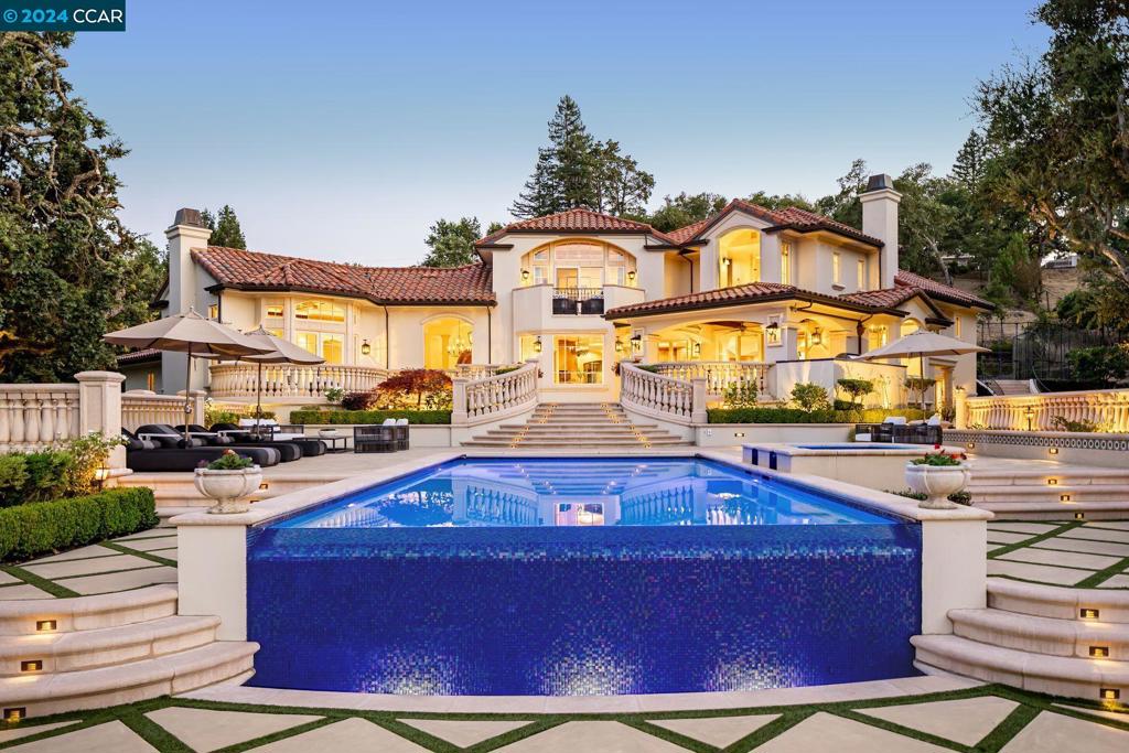 This Mediterranean estate offers peace and privacy. Descend the gently winding driveway and survey Happy Valley below. The grand living room sits under beamed ceilings and over fine hardwoods. The dining room comfortably seats 10 and commands garden views. The kitchen features top appliances and immense granite islands. Dine there either at the breakfast bar or the dining nook. The kitchen leads to one family room, with cabinetry for TV and sound equipment. Downstairs, a second family room offers more space for entertainment and play. The principal suite features beamed ceilings and garden views, and a bathroom with dual sinks, a tiled backsplash, a shower with dual heads, and a jacuzzi. Work or study from home is easy with multiple work centers: an exceptional office adjacent to the entry hall; a kitchen work station; two more stations in the family room; and an office adjacent to the principal bedroom. Outside the kitchen is the heated outdoor dining area. Descend to the pool and deck, hot tub, fireplace and grassy play area. A guest house (which could be configured as a pool house/game room) sits nearby. Parking is easy. The home is just minutes to Lafayette shopping and restaurants, and yet removed from traffic noise. For more information, go to www.4200canyonroad.com.