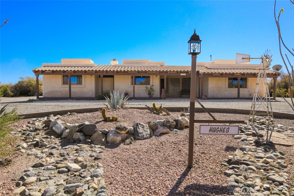 Charming Spanish-Style Home with character and space! This 3 Bedroom, 3 Bathroom home features an open floor plan with beautiful Spanish tile flooring and a double-sided stone fireplace as the centerpiece of the living area. The spacious kitchen offers an island, breakfast bar, and built-in desk—perfect for entertaining or everyday living. Generous bedrooms with large closets provide plenty of comfort and storage, plus a large laundry room with extra space for organization. Enjoy a 5-car garage with an additional carport behind the garages, ideal for vehicles, boats, or toys. Beautifully landscaped with desert plants, offering low-maintenance curb appeal. Home comes fully furnished, making it truly move-in ready. Nestled as the only home in a private cul-de-sac, just steps from the Colorado River—this is desert living at its best!