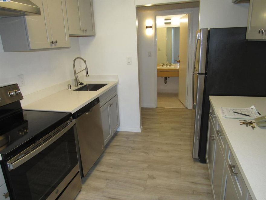 Light and bright condo on 4th floor of Parkway Towers.  Wall of windows with balconies all across....livingroom and both bedrooms.  Secured building with elevator.  Common area coin operated laundry in building.  Wood based laminate flooring throughout. Large Primary Bedroom with wall to wall closets on two sides. Updated kitchen. Gated parking, with 1 under ground parking space assigned. Community pool, clubhouse, fitness, tennis court. Centrally controlled HVAC with individual air controllers in condo.  Central location, close to BART, park, shopping, Mission Blvd., 680 and 880. Views:  Downtown