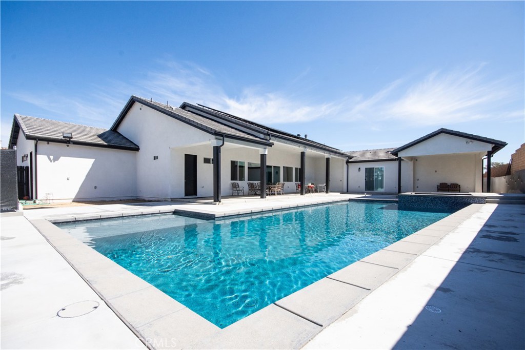 This stunning 2023 custom-built single-story pool home in Upper South Corona sits in a private cul-de-sac and offers 6,050 sq ft of living space with 8 bedrooms, each with its own private bathroom. The spacious layout includes 3 kitchens, 3 laundry rooms (main with double washer/dryer hookups), and a dedicated office. A massive 1,500 sq ft great room with 12-foot ceilings and a large fireplace is perfect for entertaining. The gourmet kitchen features granite countertops, a large center island, and stainless steel appliances. The primary suite includes a fireplace, soaking tub, custom tile shower, and walk-in closet. The home also offers 5 A/C units, 4 tankless water heaters, built-in surround sound, and 44 fully paid solar panels. Ideal for multi-generational living or rental income, the home includes a detached 2 bed/2 bath ADU with full kitchen and laundry, and an attached 1 bed/1 bath junior ADU. The resort-style backyard features a tropical Pebble Tec pool and spa, full-size pickleball and basketball courts, and RV parking—all in one of Corona’s most desirable neighborhoods.