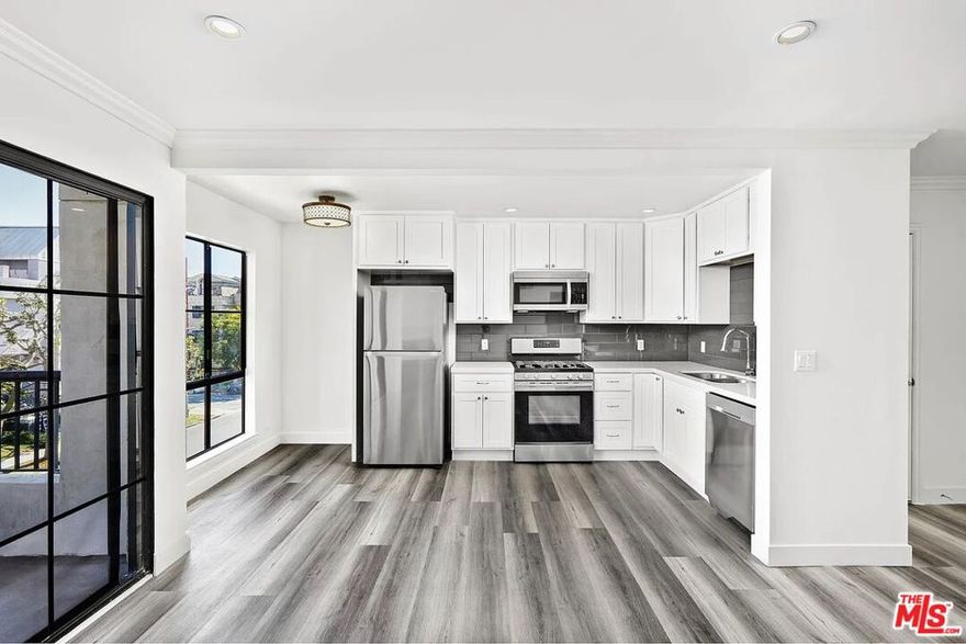 Step into this bright, top floor 2 bedroom, 2 bath corner unit set within a charming boutique building. The updated kitchen features quartz countertops, stainless steel appliances, and large black-framed windows that fill the space with natural light. A spacious front-facing patio overlooks Croft Avenue and includes a bonus storage closet.The living area offers a cozy fireplace, while the primary suite features a walk-in closet and an ensuite bath. Additional highlights include central A/C, in-unit laundry with storage, and two assigned parking spaces in a gated garage. Just two blocks from Melrose Place. Pet-friendly.