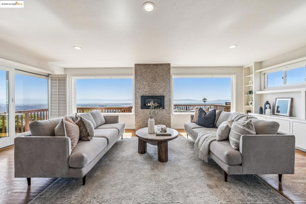 Perched to capture sweeping views of the Bay—including all four iconic bridges—this stunning Mid-Century Modern home blends timeless design with modern upgrades. This split-level residence offers both charm and contemporary comfort. The main level is perfect for entertaining, featuring a spacious open-concept living area with rich wood flooring, recessed lighting, custom built-ins, a dramatic stone fireplace, and oversized picture windows that frame the breathtaking views. Step outside to the expansive deck or patio and enjoy the ultimate indoor-outdoor lifestyle—ideal for relaxing or hosting with the Bay as your backdrop. The updated kitchen is a chef’s dream, showcasing natural shaker-style cabinetry, granite countertops, a white porcelain farmhouse sink, stainless steel appliances, a breakfast nook, and plantation shutters. Upstairs, you'll find three bedrooms, including a generous ensuite primary. The recently renovated guest bathroom offers modern finishes and thoughtful design. New central heating and air conditioning system with new ducting throughout the home, complete repiping of the entire house, new exterior paint, freshly landscaped front & back yard. The lower level includes the garage, office space, half-bathroom, laundry, & convenient access to the backyard patio.
