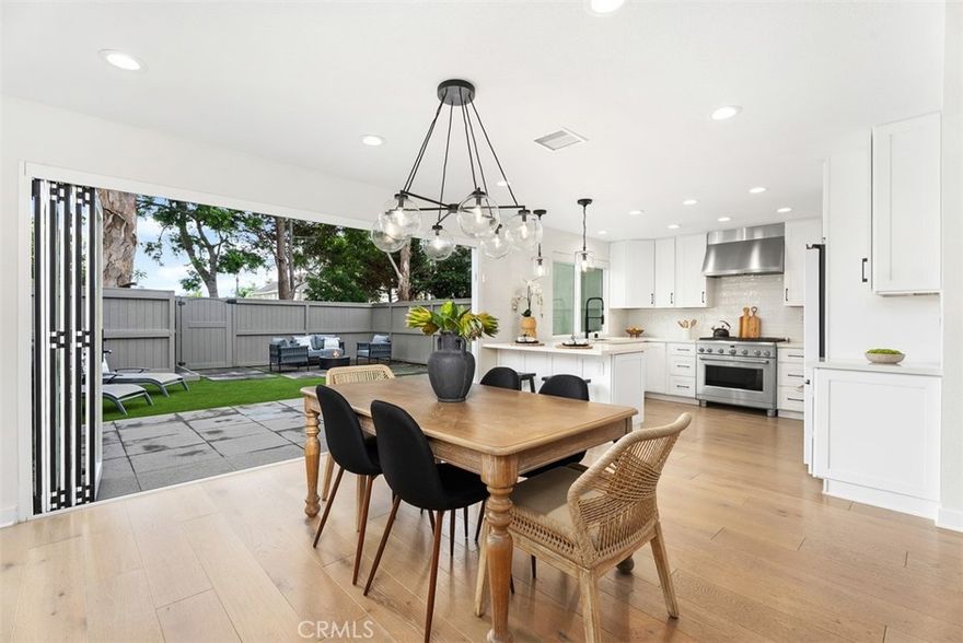 Beautifully remodeled down to the studs in 2021, this 3-bedroom, 3-bath single family attached home showcases high-end finishes from that renovation, including a quartz-topped built-in buffet with under-counter dual refrigeration, full home automation, new HVAC and ducting, new windows, recessed lighting and designer fixtures, and soft-close drawers and cabinets.  Current upgrades include brand-new carpet, custom roller shades, epoxy garage floor, Noritz tankless water heater, and new built-in quartz-topped cabinetry that frames a sleek, modern tiled electric fireplace. The chef’s kitchen boasts quartz countertops, breakfast bar, premium GE Café appliances, and a walk-in pantry with an additional lighted storage area under the staircase.
The open, light-filled layout features beautiful hardwood flooring and flows through a 12-foot accordion glass door to a serene private backyard, perfect for indoor-outdoor entertaining.  All bedrooms feature vaulted ceilings and abundant natural light. The primary suite includes a walk-in closet, dual vanities, and a large walk-in shower, while the downstairs bathroom also offers a spacious walk-in shower.  Additional highlights include a gated private front patio with potential for a room addition connecting to the garage, overhead garage storage with utility sink and laundry hookups, and ADU potential within this Beachwalk community. The home is ideally located near one of the four additional satellite pools located throughout the neighborhood.
Set on a quiet cul-de-sac with plentiful guest parking, residents enjoy the community’s Jr. Olympic-sized saltwater pool, spas, saunas, lush greenbelts, sand volleyball courts, and newly renovated clubhouses. Access includes an automated gated entrance from 17th Street as well as non-gated guest access from Goldwest Street. Just minutes from the sand, Pacific City, top-rated schools, and all the amenities of Downtown Huntington Beach, this home delivers resort-style living and modern coastal elegance.