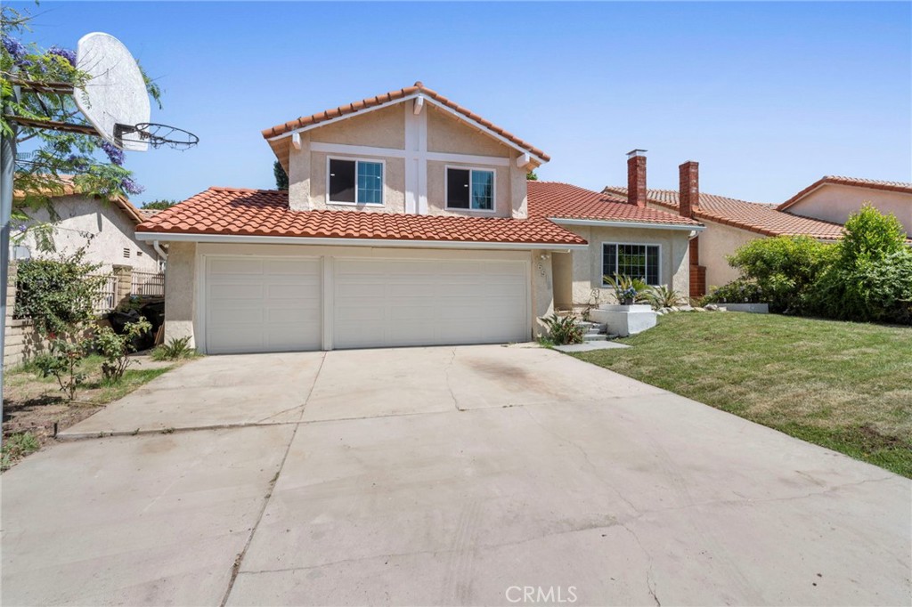 Discover this beautifully remodeled tri-level home in sought-after Granada Hills, offering the perfect blend of modern elegance and family comfort. Boasting 5 spacious bedrooms and 3 updated bathrooms across 2,769 square feet, this residence sits on an expansive nearly 7,500 square foot lot. The inviting living room welcomes you with soaring vaulted ceilings, wood-style flooring throughout, and a charming wood-burning fireplace, seamlessly flowing to a formal dining area highlighted by a custom chandelier—ideal for hosting memorable gatherings. The contemporary kitchen is a chef’s dream, featuring crisp white cabinetry, quartz-style countertops, stainless steel appliances, and a sunlit breakfast nook overlooking the backyard. Upstairs, the luxurious primary suite showcases a remodeled en-suite bath with high-end finishes, modern fixtures, and a walk-in closet, while additional bedrooms and a remodeled hall bath offer flexibility for family, guests, or a home office. Downstairs, an extra-large bedroom with an adjacent full bath is perfectly suited for guests or multi-generational living. Step outside to a private backyard oasis with a spacious tiled patio, wood cover, mature fruit trees, and ample room for entertaining, gardening, or relaxation. Completing this ideal package is a three-car garage with abundant storage, plus easy access to shopping, dining, and transportation. Experience modern comfort, space, and style—make this move-in ready home yours today!
