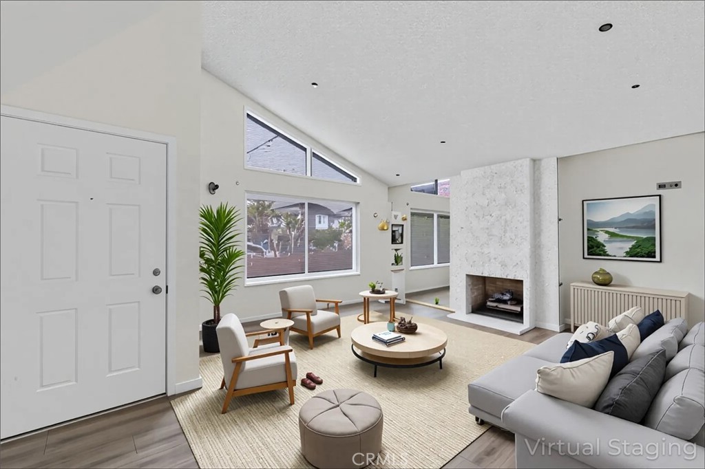 Single-Story Beauty with Vaulted Ceilings, Fireplace & Outdoor Entertaining Spaces tucked away on a peaceful cul-de-sac on the border of Huntington Beach with SOUND PROOF WINDOWS! This 3-bedroom, 2-bath home offers just over 1,300 sq. ft. of stylish comfort and low-maintenance living. Step inside to a bright, open living room where soaring vaulted ceilings and a cozy fireplace create the perfect spot for gatherings with family and friends. The seamless flow into the dining area and kitchen makes entertaining a breeze. The kitchen is very spacious and is begging for a large island to be installed while still providing space for a nook table. An extra large slider provides access to the backyard which is fully paved, giving you beautiful, usable outdoor space without the upkeep—ideal for BBQs, al fresco dining, or a morning cup of coffee in the sunshine. The primary bedroom has a dramatic entrance with a double door entry and a walk in closet. All of the bedrooms have ceiling fans and some other recent upgrades include: a newer roof, electrical, plumbing and neutral laminate flooring throughout the home! Both bathrooms have been remodeled with stone countertops, newer vanities and recessed lighting. The two-car garage provides plenty of parking and storage, space for washer and dryer and a space saving roll up garage door. Additionally, there is also a full two car driveway. Located just 1 mile from the freeway and 4 miles to Long Beach's beautiful PCH & 2nd shopping center the location couldn't be more ideal. With its desirable single-story layout, charming upgrades, and great location, this home is move-in ready and waiting for you. Don’t miss your chance to live in this perfect blend of comfort, style, and convenience!