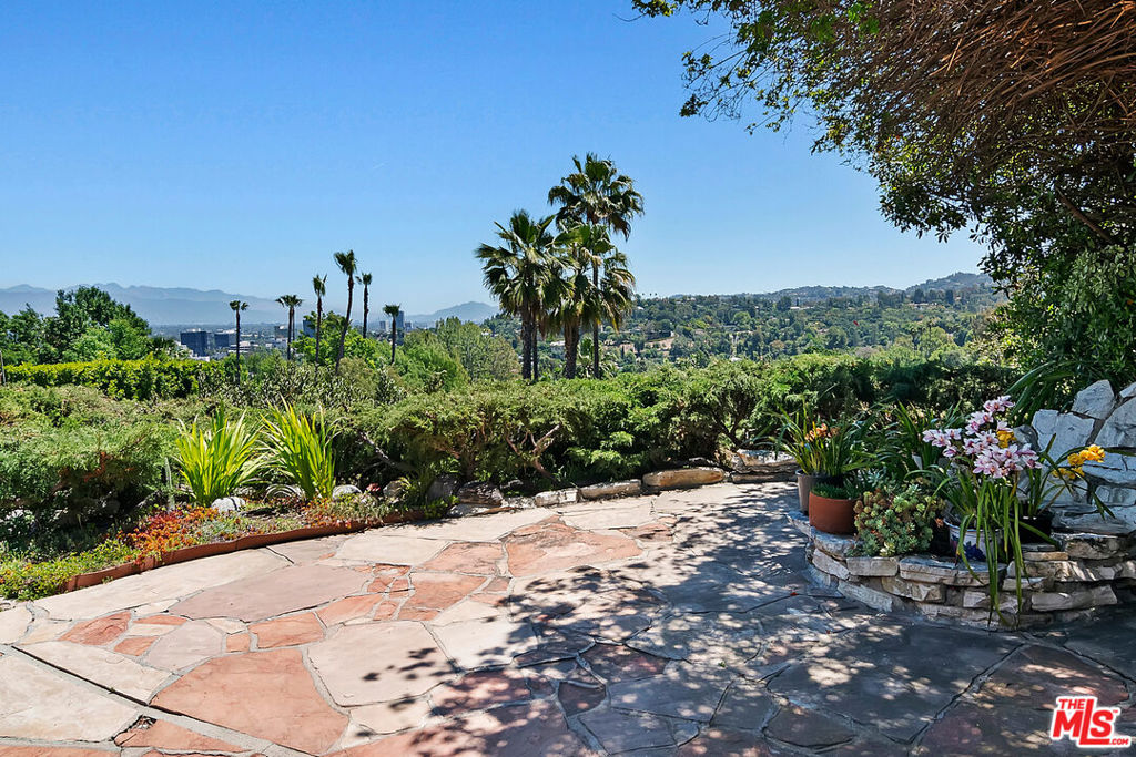 Views, views and more views! Welcome to your Personal Private Garden Oasis! Nestled south of Ventura Blvd and perched above the prestigious Clark Gable Estates, this incredible property offers breathtaking panoramic views of the San Gabriel, Verdugo, and Santa Monica mountain ranges, along with twinkling city lights of the San Fernando Valley and surrounding hills all while providing privacy and seclusion. Owned by the same family since 1961, this is a rare opportunity to own a timeless plot of land in the hills of Encino that has not been on the market for over six decades! This single-story home boasts approximately 2,500 sq. ft. of living space on an expansive almost half-acre lot. Inside, you'll find five spacious bedrooms, three full bathrooms, a grand living room with a cozy fireplace, and a dining room with a wet bar, perfectly positioned to capture the home's breathtaking scenery. Outside, the massive frontage (240 feet) and four distinct yard spaces (front, back, and two sides) offer endless possibilities for outdoor enjoyment. The lush grounds feature established gardens brimming with fruit trees, including avocado, guava, cherry, and peach just to name a few. Custom stonework adds character throughout the property, while the electric awning in the backyard creates the ideal shaded retreat. Updated kitchen appliances include oven, stovetop, dishwasher, and range hood. Updated sewer lines all the way out to the street. Many plumbing and electrical updates throughout. Newer dual attic fans. All the comforts of home await you, but can also be further updated and customized into your unique vision. The neighborhood is known for its serene atmosphere, elegant custom homes, and coveted location. Whether you wish to move right in or transform the property into a personalized masterpiece, the potential here is limitless. Whether it's enjoying a glass of wine as the sun sets, hosting unforgettable BBQs for Super Bowl Sunday, or simply retreating to your peaceful sanctuary after a long day this particular home delivers a lifestyle unlike any other. Don't let Google Street View fool you. This property must be seen in person to appreciate its true magic. Schedule a showing today and make this gorgeous home yours!