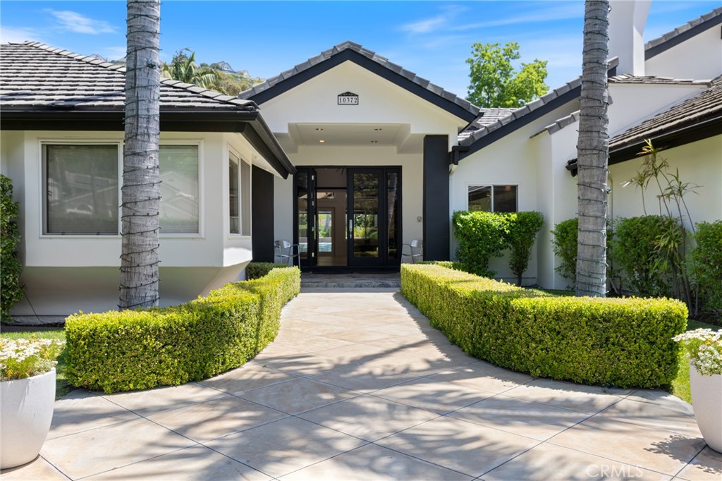 Welcome to your dream home—a spectacular single-story estate set on nearly one acre of lush, beautifully landscaped grounds. Tucked behind a private gated entry, this expansive residence offers approx 7,000 square feet of luxurious living space, thoughtfully designed across two wings that converge into stunning communal areas. At the heart of the home is a show stopping open-concept kitchen and family room, featuring wall-to-wall windows that frame sweeping views of the backyard oasis. The adjoining dining room is ideal for hosting large, festive gatherings with ease and elegance. The private east wing features two spacious en-suite bedrooms, including a lavish primary suite complete with a fireplace, spa-inspired bath with oversized shower, freestanding tub, separate toilet and bidet, and a generous walk-in closet. The west wing offers two additional bedrooms—one en-suite—and a stylish home office, providing flexibility for family, guests, or workspace needs. Each room has been meticulously remodeled with high-end materials and thoughtful design details that exude both comfort and sophistication. Custom cabinetry, premium appliances, and designer finishes elevate every corner of this extraordinary home. Above the four-car garage is a separate, private-entry apartment—a versatile open-concept layout with distinct living, kitchen, and sleeping zones, ideal for guests, in-laws, or a home studio. This exceptional bonus space is perfect for extended stays, creative endeavors, or income potential. The grounds are nothing short of breathtaking. A motorized gate opens to an expansive motor court with ample space for a dozen vehicles, including room for an RV or boat. The professionally designed landscape combines the charm of an English garden in front, while the backyard offers a resort experience: a covered patio, a high-end BBQ island, sparkling pool with elevated spa, sprawling lawn, gazebo, and dozens of mature trees for privacy and beauty. A charming casita just off the pool features a kitchenette and full bath, making it perfect for guests or a poolside retreat. The entire property is a harmonious blend of nature and design—ideal for entertaining, relaxing, and enjoying SoCal coveted indoor-outdoor lifestyle. This is a rare opportunity to own a fully renovated estate of this scale and privacy in one of Orange County’s most desirable areas. Don’t miss your chance to experience the perfect blend of elegance, comfort, and refined living. Your new home awaits.