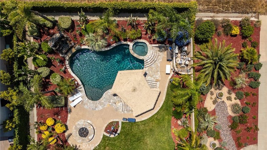 Cleveland Way in South Corona’s single-story offers formerly model home, this maintained property boasts golf courses. The home primary suite with a spa-like bath, double-sided fireplace, and private retreat opening to the patio. All bedrooms furnished with ceiling fans. Kitchen featuring Sub-Zero refrigeration, double ovens, and polished travertine floors. Theater room. Guest suite with private entrance. 24 owned solar panels for energy efficiency. The Ultimate Backyard Escape: Step into your own paradise, designed for entertaining and relaxation: Sparkling pebble-tech salt water pool with a swim-up bar: Handcrafted palapa with thatch roof, built-in BBQ, and premium outdoor kitchen: Raised hot tub, cascading waterfall, and stone firepit: lounge decking surrounded by tropical greenery: RV-friendly side yard (potential for covered parking), also equipped with whole house water softener and alarm system. Prime Corona Living. Walkable greenbelt trails leading to scenic parks. Minutes from The Crossings, Dos Lagos Shopping, and top golf courses (Eagle Glen, Hidden Valley & more) Highly acclaimed schools in a sought-after neighborhood.