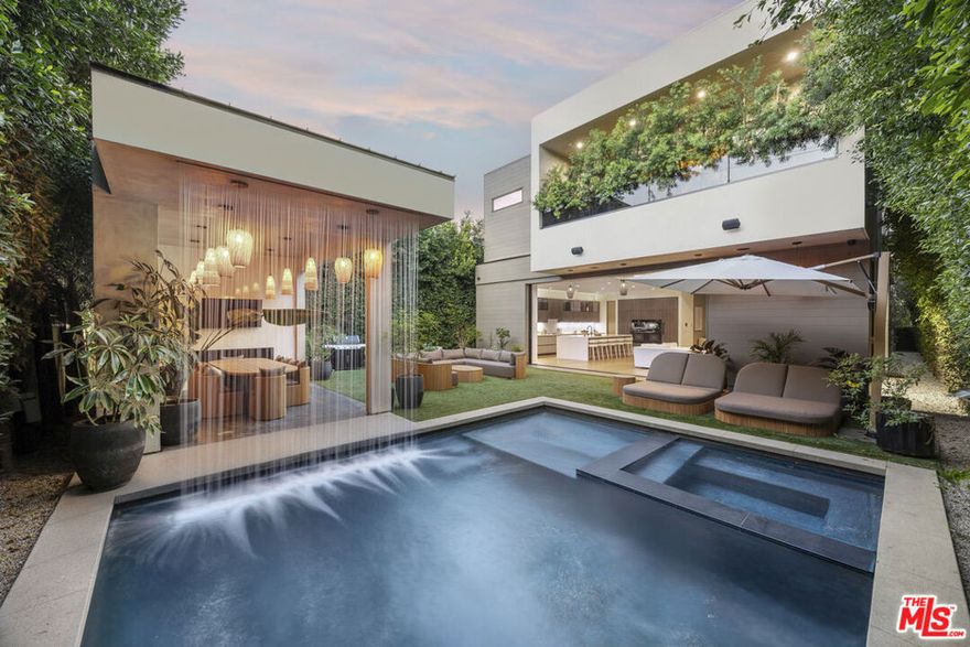The Alfred residence is a masterpiece of organic contemporary design that balances indoor and outdoor living, located on one of the most coveted streets in West Hollywood. This home's expansive open-concept floor plan spans over 6,110 square feet on an oversized lot with 5 bedrooms, 5.5 bathrooms, an entertainer's backyard, a private movie theater, and 2-car garage. With 12-foot ceilings and floor-to-ceiling windows, natural light pours into every room. Open the living room's custom sliding glass pocket doors to blur the transition between indoor and outdoor when entertaining friends and family. The backyard evokes the beauty of Tulum, with tall and lush hedges providing serene privacy. The covered lime-wash outdoor lounge area includes an integrated sound system, designer pendant lighting, fireplace, and flat-screen TV, creating the ideal space for alfresco dining and entertainment. Spend your evenings preparing dinner in the kitchen while you watch the sunset pour in over stunning views of the backyard, pool, & waterfall. The custom-designed kitchen comes equipped with a massive oversized marble island, two dishwashers, two ovens, a walk-in pantry, and a full suite of Miele appliances including an in-wall fully automatic espresso machine. Moving upstairs, the Alfred's palatial double-sized primary suite is a true sanctuary, featuring a private balcony with floor-to-ceiling sliding glass doors overlooking the backyard, a luxurious walk-in closet, and cozy fireplace. The spa-inspired bathroom is outfitted with oversized marble slabs, a freestanding soaking tub, a frameless glass shower, a vanity, his and hers sinks, and a Toto toilet. The junior suite is comprised of a bedroom and en-suite, each with its own dedicated full bathroom, and a balcony overlooking tree-lined Alfred Street. This unique configuration offers ultimate practicality, with the en-suite being used as an office, den, creative space, playroom, or bedroom. Back downstairs, the Alfred's dedicated home theater is equipped with a cinematic projector and surround sound - subwoofer included - providing the ultimate at home entertainment experience. Additional amenities include, Control4 smart home system controlling lights, speakers, climate, and security, Motorized blackout roller blinds in all bedrooms, controllable via mobile app, Pool and spa heaters controllable via mobile app, Commercial grade wifi mesh network, Front door ring camera and 9-camera security surveillance system with remote live feed access and 24/7 recording to a local secure hard drive. Downstairs: living room, dining room, kitchen, movie theater, office, guest bathroom.  Upstairs: primary suite, junior suite and en-suite, guest suite & laundry room.  With this home's amazing location, you can easily walk to anything you need. Sushi Fumi, Urth Cafe, Great White Melrose, Alfred Coffee, Melrose Place, the Beverly Center, the list goes on and on. Get out and enjoy the beautiful California weather every day, year round.