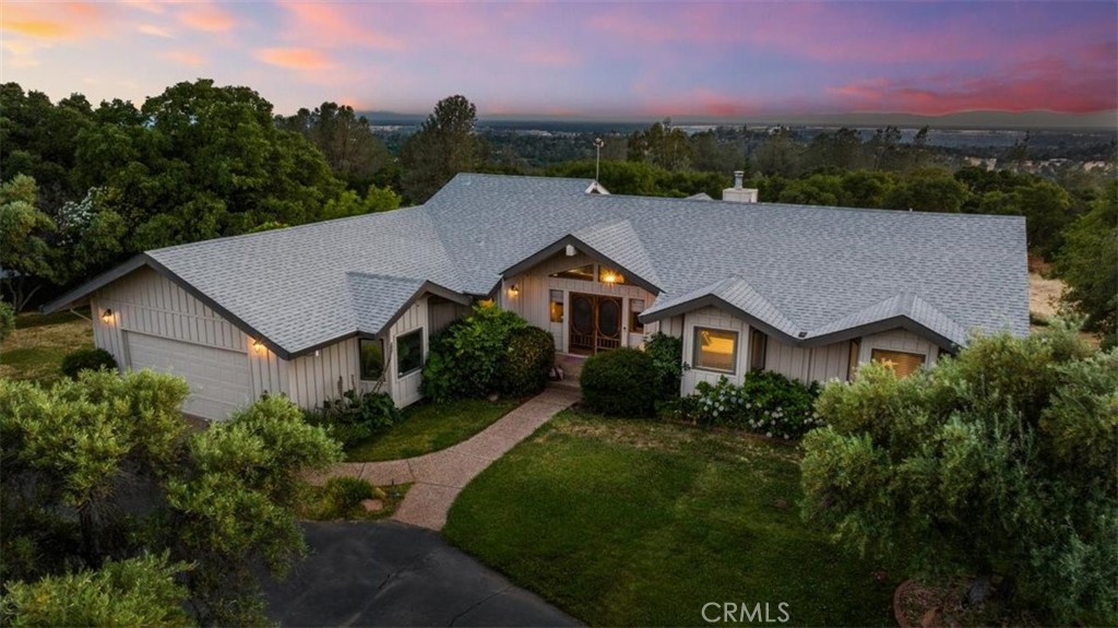 Stunning custom home on 4.7± usable acres in one of Oroville’s most desirable areas. Privately tucked back off a long paved driveway, this property offers space, privacy, and all the extras. Main level features 3 bedrooms including a spacious primary suite with clawfoot tub and walk-in shower, plus a second full bath and half bath off the modern country kitchen. The living room has vaulted wood ceilings, fireplace, and wraparound windows with sweeping views. Downstairs is an entertainer’s dream — a massive game room with bar, pool table, shuffleboard, workout space, and private guest suite with full bath. Step outside to a fully fenced pool area with diving board, cabana, and palm trees. Oversized laundry with hidden chute, storage, and craft area. Attached 2-car garage with built-in cabinets and workbench, plus a detached 4-car garage with 220 power and sink. RV/boat carport with lighting and outlets. Other features include a dog run, deer-proof garden, chicken coop, fruit trees, quad/dirt bike trails, newer roof, and room for additional structures. Shown by appointment only — do not access driveway without scheduled showing.