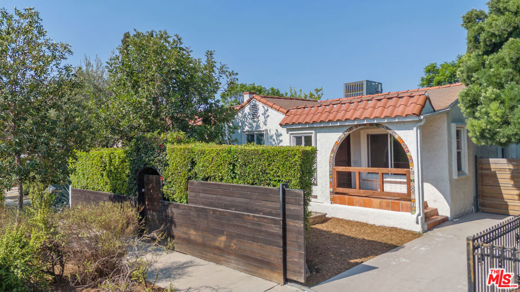 A hidden gem nestled discreetly behind a lush wall of hedges, this utterly private Atwater Village Spanish is perfectly situated in one of NELA's most pedestrian friendly neighborhoods. Designed for those who crave space and flow, the sun-drenched, open-concept layout unfolds gracefully from the moment you enter. The generous living and dining areas, anchored by beautiful original hardwood floors, lead seamlessly to an updated kitchen. Complete with a center island and sleek stainless appliances, this space is a perfect hub for everything from quiet mornings to lively gatherings. Two spacious bedrooms and two modern, updated bathrooms are accessed via a central hallway, providing a comfortable and intuitive layout. Tucked away at the back of the home, the primary suite is a true sanctuary, featuring a walk-in shower and ample closet space with easy access to the outside. Beyond the home, a fully fenced lot provides privacy and security with a sizable patio featuring built-in bench seating, numerous fruit bearing trees, a veggie garden and green lawn, ideal for a bit of play or a moment of zen. The finished, detached garage is a unique and inspiring bonus space, with an oversized sliding door, vaulted tongue and groove ceiling and a mini-split for year-round heat and air, making it the ultimate home office, creative studio or private retreat you've been searching for. Located north of Los Feliz Blvd, this ideal location is just blocks from the beloved Village Bakery, The Morrison, historic Tam O'Shanter and all that Atwater Village has to offer! Ready for immediate occupancy.