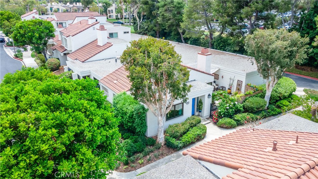 LARGEST SINGLE-STORY GROUND-LEVEL TOWNHOME IN COMMUNITY, NO ONE ABOVE OR BELOW ON CORNER LOT ACROSS FROM POOL AND SPA WITH ONLY ONE ATTACHED WALL AND HIGHLY DESIRABLE DIRECT-ACCESS 2-CAR GARAGE WITH STORAGE. Views of greenery from all windows. Open floor plan, cathedral ceilings and many large windows bring in lots of natural light. Living room with upgraded stone fireplace is open to dining room and open to beautifully remodeled kitchen with breakfast bar, recessed lighting, granite countertops, stainless steel appliances, and food pantry. Kitchen and living room windows and sliding glass door open to large private front patio with landscaping, decking, patio cover, block walls and gate, where you can relax and barbeque. Luxurious engineered wood flooring throughout with Travertine tile flooring in the bathrooms. Large primary bedroom with expansive windows on side of home has its own private full bathroom including vanity area, linen closet and separate shower with privacy door. Down the hall is a second full bathroom with walk-in shower, and a second spacious bedroom with recessed lighting and windows to the front. Newer Central A/C, dual-pane windows, newer water heater and smooth ceilings. Acclaimed Irvine School District, including University High. Next to San Joaquin Golf Course, Racquet Club of Irvine and Rancho Senior Center. Conveniently located near UCI, William Mason Park, John Wayne Airport, Newport Beach, Fashion Island and walking distance to shops and entertainment. Water, trash, exterior maintenance included in HOA dues. A remarkable opportunity!