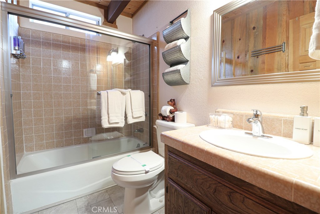 Check out this gorgeous gambrel style beauty!!Looking for that peaceful "cabin in the woods" feel? This is it!! Just steps to the National Forest and hiking trails! This street to street property is perfect for some serenity, but still close to all the amenities! Only minutes to the lake, the slopes, grocery stores, and walking distance to the local Community Market! Already an active vacation rental; this one is fully furnished and ready to go! Would make a wonderful full time residence, short term vacation rental or a family vacation home! This home boasts two bedrooms and a full bath upstairs, a full bath on the main level and a wrap around deck to enjoy the peaceful nature surroundings. Soak in the jacuzzi with a glass of wine while soaking in the sounds of the forest! Indulge in a cup of coffee in the mornings on private balcony off the main bedroom! Wrap around deck is perfect for outdoor entertaining in the summer, with plenty of room for your family and friends! Paved driveway area for easy access. This beautiful Big Bear cabin awaits you!!!