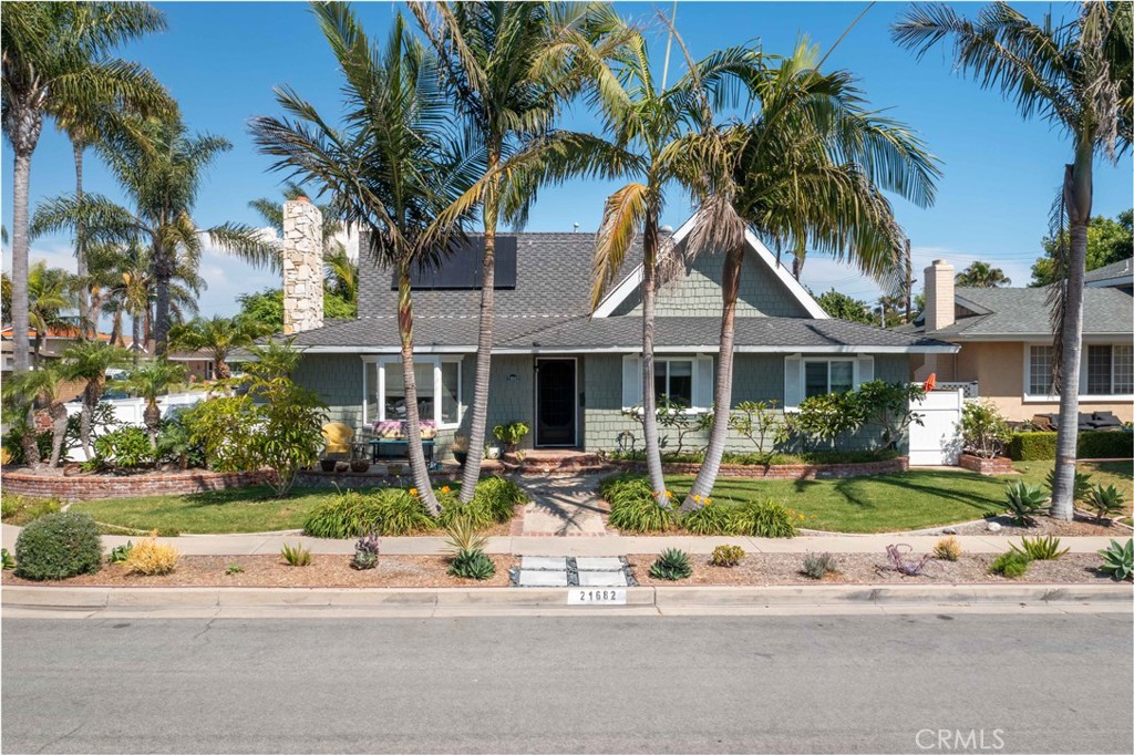 Welcome to coastal beach living at its finest! This beautifully remodeled single-level home, set on a spacious 7,000 SF corner lot with RV parking, offers versatile living with Hawaiian-inspired curb appeal, blending character, comfort, and flexibility. It’s the ultimate Southern California beach lifestyle. The thoughtful layout includes two distinct living areas with two kitchens, giving you the option to enjoy it as one expansive residence or adapt it to your needs—whether a traditional home, private guest quarters, or income property. The home offers air conditioning and solar panels that are leased. As you enter, you are greeted with natural hardwood floors that lead to the double doors of a spacious living room with a bay window, brick fireplace, and 2nd kitchen, which boasts quartz countertops, glass tile backsplash, modern cabinetry, and a gas stove—perfect for hosting, extended stays, or flexible living. Beyond this, the dining area, enhanced with recessed lighting, flows into a large family room featuring vaulted wood-beam ceilings, a 2nd fireplace, a wood-paneled accent wall, built-ins, and four skylights—creating an open, airy environment ideal for everyday living and entertaining. The main kitchen is well-appointed with granite countertops, stainless-steel appliances, ample white cabinetry for storage, and tile backsplash, while a pass-through window connects the kitchen to the family room for seamless entertaining. A convenient laundry room with storage and counter space is adjacent to the kitchen. The primary suite features backyard access and an en-suite bathroom with travertine walk-in shower, a 2nd closet space, and travertine flooring. Secondary bedrooms include hardwood floors, ample light, ceiling fans, and generous closets. The hall bath offers a granite-topped vanity, tub/shower combo with tile, and custom tile flooring. The expansive corner lot is a private retreat with multiple patios, a wood deck, covered cabana lounge, firepit, and lush landscaping—perfect for entertaining or relaxing. All just minutes from Huntington Beach’s sandy shores, award-winning schools, parks, library, shopping, and dining—this isn’t just a home, it’s a lifestyle opportunity with timeless coastal charm.