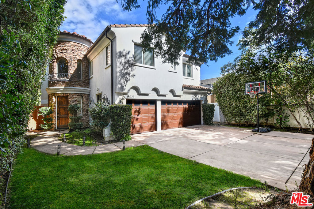 You still can't believe you found this house. 15525 Morrison feels like the kind of home you'd dream about while on vacation. It's rare to find a place that feels luxurious and family-friendly. From the moment you pull up to this tree-lined street in the Hesby Oaks School District, you know this home is special. Set behind private gates and wrapped in tall, leafy hedges with the gentle rustle of palm fronds above, the house is tucked away, quiet, safe, and peaceful. Exactly the kind of place you've always hoped to raise your kids. When you step inside, it's just wow. The soaring ceilings, those beautiful arched windows, sunlight dancing off whitewashed walls bathing everything with a golden glow, everything feels warm and open. The layout is perfect for family life. The flow is open and fluid, The serene and open atmosphere is warm, inviting, and impeccably maintained. The living room is big and bright, and it flows right into the family room. From there, step into the entertainer's kitchen, where sleek quartz countertops glisten and bar seating invites sunlit breakfasts with friends. We can already picture pancake breakfasts, holiday dinners, and everything in between. The design is intentional and intuitive, with one bedroom on the main level, ideal for visiting guests or grandparents, and four more upstairs bedrooms. At the top of the stairs, a sun-drenched lounge area awaits flexible space for your home office, private gym, homework station for the kids, or creative studio perfect for every stage of family life. The vibe throughout the house is one of elevated calm; every detail is thoughtful, every space a canvas for your lifestyle. Upstairs, the expansive primary suite offers sanctuary at its finest. A double-sided fireplace sets the tone for relaxed luxury, while the newly reimagined spa-inspired bathroom, pampers with a steam shower, oversized soaking tub, and top-to-bottom designer finishes. The backyard has a shimmering pool and spa with a cascading waterfall, an al fresco BBQ kitchen for unforgettable summer evenings under the string lights, and a wide grassy lawn where kids can roam. It's made for birthdays, backyard camping, and spontaneous summer neighborhood night dinners and peaceful twilight moments under the stars. It's a space crafted for connection, celebration, and total relaxation. You can vividly envision your kids growing up here, your family traditions forming, and memories being made. With a three-car garage, room for three more in the driveway, and unbeatable access to Ventura Boulevard, the 101, and the 405, convenience meets luxury at every turn. With its romantic architecture, resort-style amenities, and family-friendly functionality, effortless elegance, all in the heart of the coveted Hesby Oaks School District, 15525 Morrison is a rare blend of classic beauty and everyday ease.