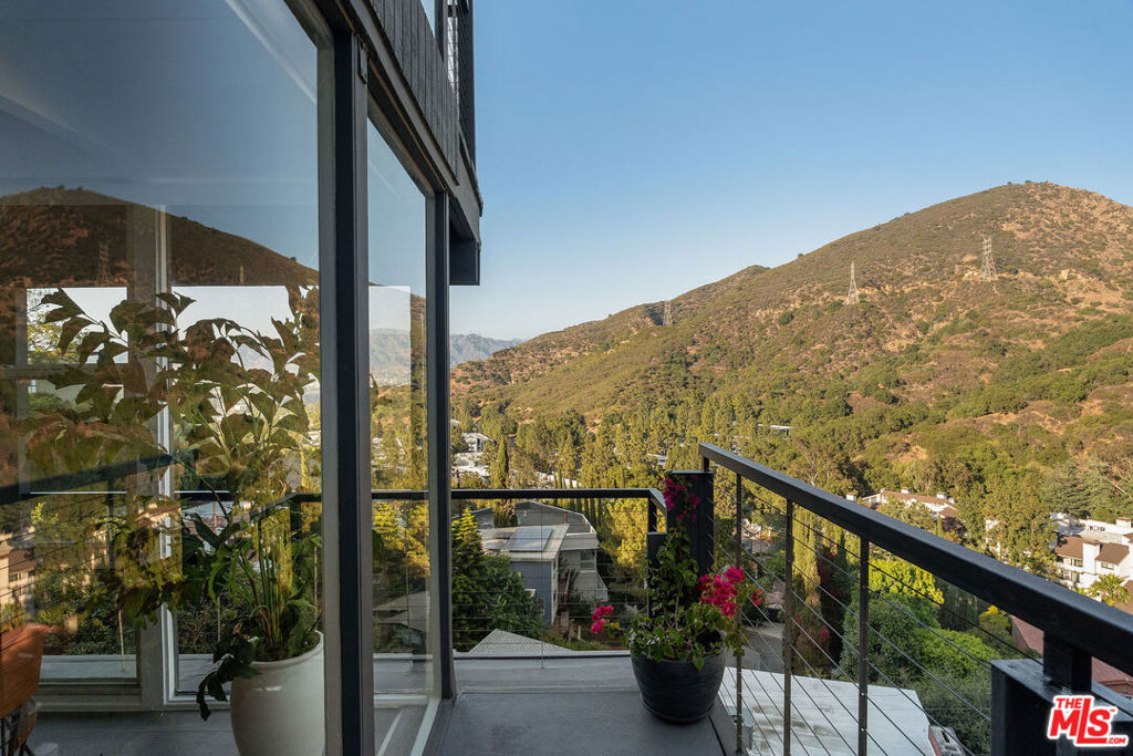Mid-Century Post & Beam with Jetliner Views near Lake Hollywood. Originally built by 1940s film actor turned real estate developer John Compton, best known for his role in the Jesse James series, this timeless 3BD/2.5BA Post & Beam is a rare piece of Hollywood history. Perched high above Lake Hollywood on a peaceful street, the home embodies the soul of classic California modernism clean lines, floor-to-ceiling glass, and a seamless indoor-outdoor connection that invites light, air, and stunning views into every corner. It captures sweeping panoramas that stretch from the hillsides to the city skyline and sunsets that will leave you breathless. Inside, a stylish island kitchen anchors the open floor plan, flowing effortlessly into light-filled living and dining spaces designed for both relaxed living and memorable gatherings. The primary suite is a true retreat, featuring a spa-like bath and two private terraces with panoramic views perfect for morning coffee or golden hour unwinding.A newly built deck expands your living space outdoors, offering the perfect spot for al fresco dinners, weekend lounging, or cocktails under the stars. While there's no garage, the street parking right out front is easy to find. Extensively renovated in 2018, this house has been immaculately cared for. Modern comforts include motorized shades, updated systems, curated designer lighting from Interior Illusions, and elevated finishes throughout. Tucked just moments from scenic hiking trails, dog parks, and major studios, this home blends history, heart, and standout style in one unforgettable hillside setting. Welcome home!