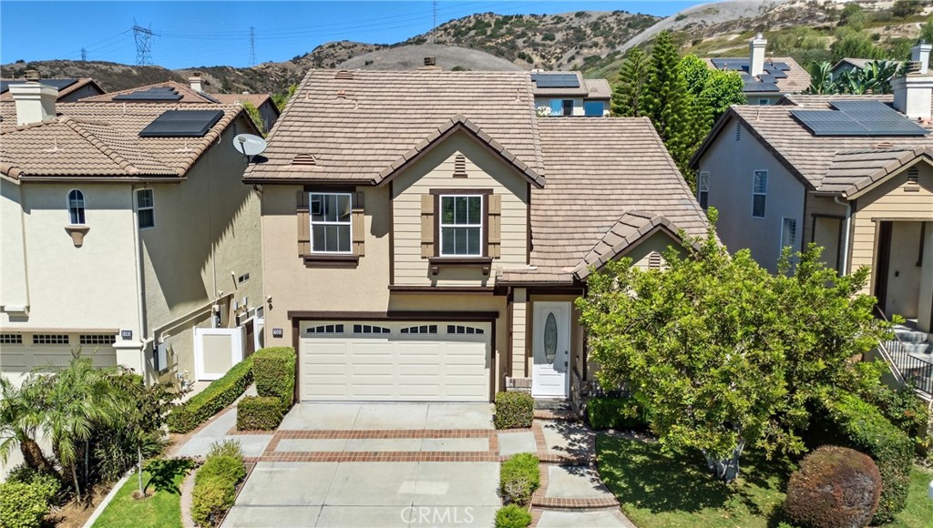 Nestled near a quiet cul-de-sac in the highly sought-after Serrano Heights community of East Orange Hills—ideally situated between prestigious Villa Park and Anaheim Hills—this impeccably maintained 4-bedroom, 3-bathroom tri-level residence offers a perfect blend of comfort, style, and functionality. A welcoming front porch greets you with serene views of the lush, landscaped front yard. Built in 2000, the home boasts a thoughtful floor plan with soaring cathedral ceilings, expansive windows, and a harmonious blend of travertine tile and wood laminate flooring. Inside, it’s adorned with shutters, designer lighting, and custom built-ins that offer both elegance and efficiency. The sun-filled formal living room provides a peaceful space to relax or entertain. The open-concept kitchen is a culinary delight, complete with stainless-steel appliances (fridge, built-in microwave, gas range, dishwasher, and trash compactor), custom cabinetry, and a travertine backsplash for added texture and warmth. A spacious breakfast bar flows into the cozy family room, where a custom media center and fireplace anchor the space. Just off the living area, you’ll find direct access to the backyard. Upstairs, a home office nook offers a quiet retreat for work or study. The indulgent primary suite is a true sanctuary, featuring custom closet built-ins and a spa-inspired bathroom with a jacuzzi soaking tub, walk-in shower, dual vanities, private water closet, and ample cabinetry. All secondary bedrooms are generously sized with large closets and access to beautifully updated bathrooms featuring hand-selected tile and travertine finishes. Additional highlights include a whole house fan, central A/C, second-floor laundry room, attached two-car garage with built-in cabinets and overhead storage, and paid-off solar panels for long-term savings. The meticulously landscaped backyard is a private paradise with mature plantings. Entertain guests under the covered patio with electric heaters, grill in the fully equipped outdoor kitchen, or unwind with a book. A large Tuff shed offers abundant storage, while a custom-built dog run with a small-pet door keeps pets secure. Every corner of this home has been lovingly curated for luxury and livability. With its prime location, thoughtful upgrades, and distinctive charm, this is more than just a home—it’s a lifestyle. Come experience the heart of Serrano Heights, where every detail is designed with purpose.