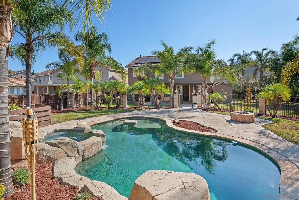 Set on a quiet cul-de-sac with no HOA, this home combines comfort and practicality with resort-style living. Inside, you’ll find flexible spaces including a downstairs bedroom and bath, a spacious loft, and a retreat off the primary suite — perfect for work, play, or relaxation. A large kitchen island anchors the living areas, enhanced by recessed LED lighting, a 40-panel solar system, and a whole-house water filtration system.The real showpiece is the backyard. An insulated patio cover with ceiling fans keeps gatherings cool, while the built-in outdoor kitchen — complete with BBQ, sink, refrigerator, warming plate, and kegerator — is built for entertaining. The sparkling pebble-tech pool and spa, framed by a dramatic rock waterfall, transform the space into a private oasis where every day feels like a getaway.