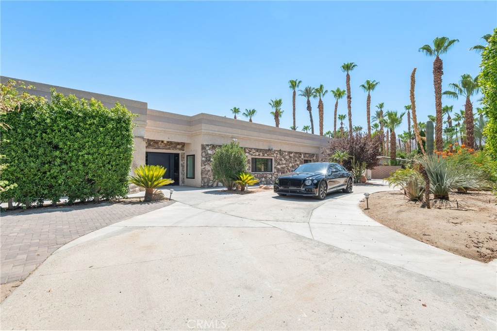 Welcome to your private, fully remodeled oasis in the exclusive Clancy Lane area of Rancho Mirage. This extraordinary 4-bedroom, 4-bathroom estate sits on an oversized 1-acre (40,946 sqft) lot offering the tranquility of a private park with lush landscaping, mature fruit trees, and luxurious finishes throughout. A circular driveway leads to a striking custom pivot front door, setting the stage for the sophisticated design inside.
Step into soaring ceilings, an open-concept layout, and abundant natural light enhanced by new modern windows and sliding glass doors. The interior showcases stylish accent walls, large-format porcelain tile flooring, modern aluminum AC registers, all-new recessed LED lighting, and exquisite Restoration Hardware chandeliers. The fully updated three-unit HVAC system, new electrical switches, and chic interior doors and moldings reflect meticulous attention to detail.
The gourmet kitchen is a designer’s dream, featuring Shinoki wood cabinetry, premium quartz countertops, ZLINE Gold Signature Series appliances, a built-in 60-bottle wine cooler, and elegant fixtures. The expansive primary suite offers direct access to the pool and deck, a spa-like bathroom with a soaking tub, oversized shower, dual vanities, and a spacious walk-in closet. Three additional guest bedrooms are positioned on the opposite wing for maximum privacy.
Enjoy resort-style outdoor living with a sparkling pool and spa, custom water features, an outdoor kitchen with porcelain and marble tile, built-in seating around a cozy firepit, a putting green, and multiple garden vignettes. The long private driveway accommodates RV, golf cart, or guest parking, plus a 2-car garage. Owned full-roof solar panels complete this turnkey, move-in ready home—just minutes from El Paseo shopping, top golf courses, fine dining, casinos and Eisenhower Medical Center.