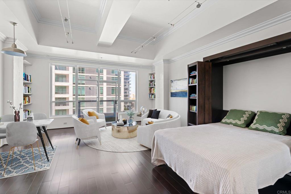 Stylish studio in the heart of downtown, just steps from Little Italy. This open-concept loft features soaring 12' ceilings, floor-to-ceiling west-facing windows that flood the space with natural light, and beautiful hardwood floors. A custom Murphy bed with built-in shelving maximizes functionality, while the updated kitchen includes Bosch appliances and designer subway tile. The spacious bathroom offers a soaking tub and modern finishes. Additional highlights include in-unit laundry (washing machine present and dryer hookup ready to go), cedar-lined closets with built-ins, a Juliette balcony and a peekaboo water view. 1 assigned parking spot with a 2nd parking spot available, inquire for details. Storage unit located just down the hall. Perfectly positioned for a vibrant urban lifestyle on the border of downtown and Little Italy, with cafés, dining, and the waterfront just outside your door.