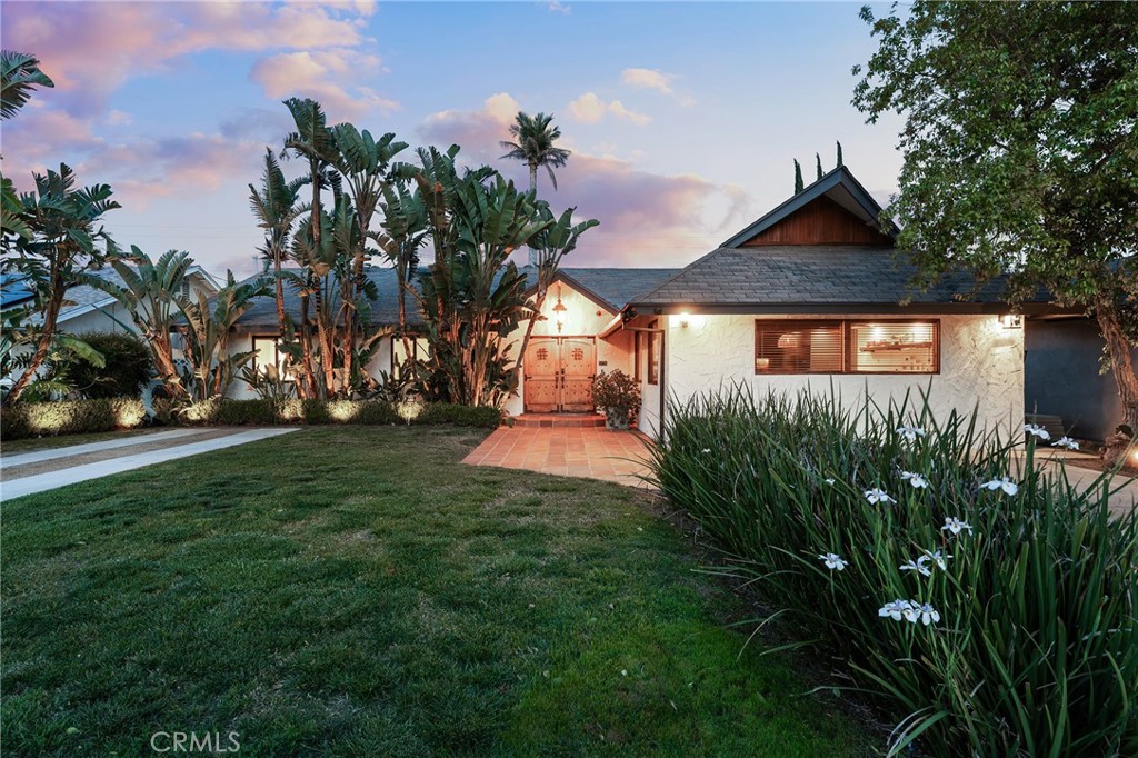 Sensational single story Spanish pool home with detached guest unit! Set back from the street with sprawling front yard with lush landscaping, grass lawn, long driveway, and second driveway ideal for RV/boat parking. A Saltillo tile pathway leads to the gorgeous double door entry. Step inside to find a completely open floor plan with designer finishes and custom details. An expansive entry foyer opens to the formal living and dining rooms featuring accent walls, oversized windows, real hardwood floors, and glass slider that opens to the backyard. The chef’s kitchen opens directly to the living spaces and boasts island with breakfast bar seating, quartz counters, soft close cabinetry, and stainless appliances. A separate large family room offers great versatility for additional flex space. There are four bedrooms in the main house including the luxurious primary suite featuring custom built-in closets and en-suite private remodeled bathroom with walk-in shower. The three secondary bedrooms each have closets with custom built-ins. A spacious remodeled hall bathroom has dual sinks and and walk-in shower. There is another full bathroom also ideal for guest use with designer tiling and walk-in shower. A separate laundry/mud room area has custom storage cabinetry. The detached guest unit is approx. 450 SF and features bedroom studio with closet, living space, kitchenette with fridge and sink, and en-suite bathroom with walk-in shower. The super private entertainer’s backyard is a true tropical oasis boasting sparking swimming pool, built-in gas fire pit, BBQ center with refrigerators and cement wraparound counter with bar seating, spacious patio adorned with Saltillo tiling, large storage room, and lush landscaping with twinkle lights that create the ultimate vacation ambiance. The property also features per seller: Control 4 smart home automation for music and lighting, Ring alarm system, security cameras, as well as brand new roof. Ideally located adjacent to dining/shopping at the Westfield Mall & Village, Warner Center, and Topanga Canyon.