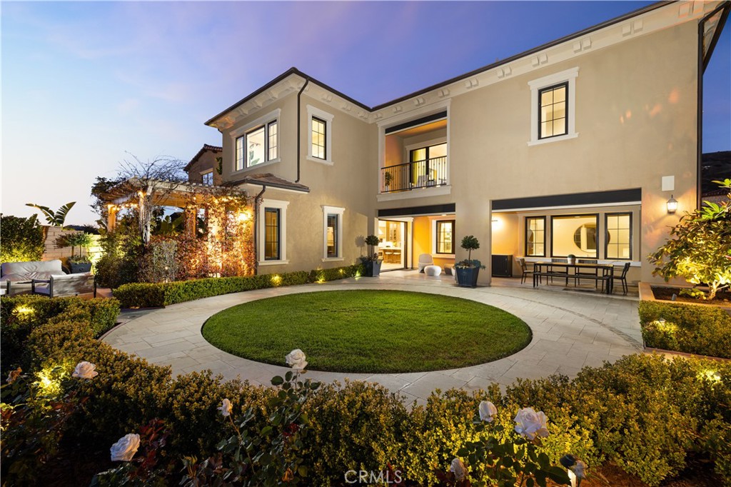 Welcome to the pinnacle of sophistication in the Bella Vista community of Orchard Hills, Irvine. This breathtaking 5-bedroom, 5.5-bathroom estate spans approx. 4,884 sq. ft., blending luxury with modern technology and exquisite design. A grand entrance with upgraded marble flooring and a custom mosaic design sets the tone for elegance. The dramatic foyer stuns with a soaring ceiling and striking spiral staircase, creating an unforgettable first impression. Rich wood flooring enhances warmth and sophistication throughout. Just off the foyer, a private office provides a refined, functional workspace. At the heart of the home, the gourmet kitchen is a chef’s dream, featuring quartz countertops, a 60”x80” SubZero refrigerator, Wolf range with griddle and hood, Bosch dishwasher, Wolf microwave, SubZero wine refrigerator, a farmhouse sink, and a large island. A butler’s pantry and walk-in pantry offer ample storage. The open-concept layout connects the kitchen, great room, dining area, and nook—ideal for entertaining. The main-level guest suite provides privacy with an ensuite bath and access to a serene outdoor patio. Upstairs, a sprawling loft leads to a balcony, capturing breathtaking city light views. The primary suite is a sanctuary, featuring a medallion marble flooring entry, a custom California Closet walk-in wardrobe, and a stunning see-through fireplace leading into a private retreat with sweeping views. The spa-like ensuite bath boasts marble floors and walls, a freestanding soaking tub, and an oversized walk-in shower. A converted office with premium California Closet built-ins and two additional ensuite bedrooms provide private havens of comfort and style. The resort-style backyard is beautifully landscaped, featuring a gazebo, tranquil fountain, lush fruit trees, flagstone and limestone pavers. Enjoy panoramic views while hosting at the built-in barbecue station, complete with a sink, gas cooktop, refrigerator, and beverage drawers creating the ultimate entertainer’s paradise. Modern convenience meets luxury with a Control4 smart home system managing AC, security, some lighting, and smart locks. Owned solar and a soft water system enhance efficiency and comfort. A spacious 3-car garage and extended driveway accommodate six vehicles. Residents enjoy world-class amenities in this guard-gated community, including a resort-style pool, spa, clubhouse, outdoor barbecue and cooking areas, tennis courts, playgrounds, and scenic biking and hiking trails.