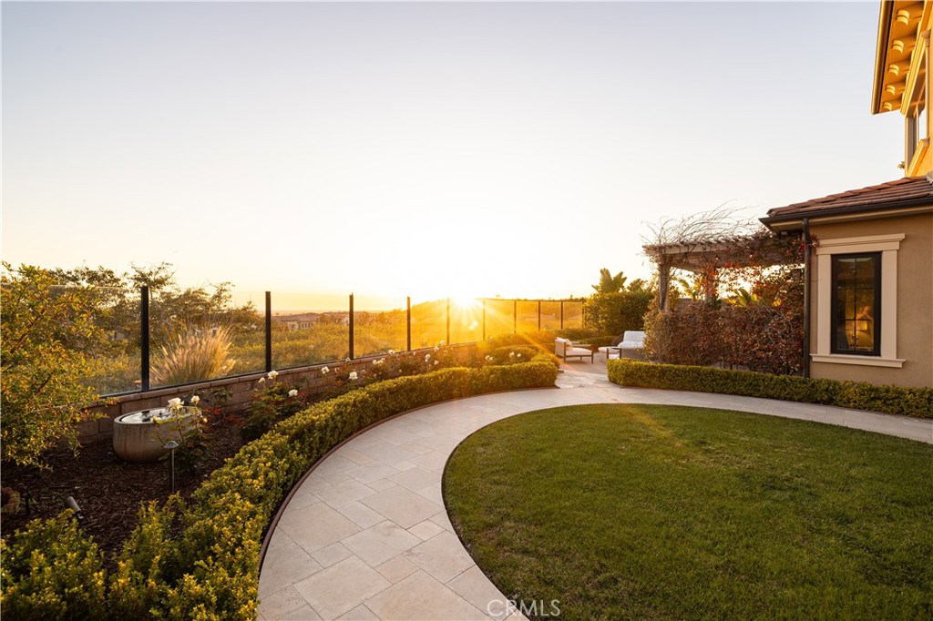 Welcome to the pinnacle of sophistication in the Bella Vista community of Orchard Hills, Irvine. This breathtaking 5-bedroom, 5.5-bathroom estate spans approx. 4,884 sq. ft., blending luxury with modern technology and exquisite design. A grand entrance with upgraded marble flooring and a custom mosaic design sets the tone for elegance. The dramatic foyer stuns with a soaring ceiling and striking spiral staircase, creating an unforgettable first impression. Rich wood flooring enhances warmth and sophistication throughout. Just off the foyer, a private office provides a refined, functional workspace. At the heart of the home, the gourmet kitchen is a chef’s dream, featuring quartz countertops, a 60”x80” SubZero refrigerator, Wolf range with griddle and hood, Bosch dishwasher, Wolf microwave, SubZero wine refrigerator, a farmhouse sink, and a large island. A butler’s pantry and walk-in pantry offer ample storage. The open-concept layout connects the kitchen, great room, dining area, and nook—ideal for entertaining. The main-level guest suite provides privacy with an ensuite bath and access to a serene outdoor patio. Upstairs, a sprawling loft leads to a balcony, capturing breathtaking city light views. The primary suite is a sanctuary, featuring a medallion marble flooring entry, a custom California Closet walk-in wardrobe, and a stunning see-through fireplace leading into a private retreat with sweeping views. The spa-like ensuite bath boasts marble floors and walls, a freestanding soaking tub, and an oversized walk-in shower. A converted office with premium California Closet built-ins and two additional ensuite bedrooms provide private havens of comfort and style. The resort-style backyard is beautifully landscaped, featuring a gazebo, tranquil fountain, lush fruit trees, flagstone and limestone pavers. Enjoy panoramic views while hosting at the built-in barbecue station, complete with a sink, gas cooktop, refrigerator, and beverage drawers creating the ultimate entertainer’s paradise. Modern convenience meets luxury with a Control4 smart home system managing AC, security, some lighting, and smart locks. Owned solar and a soft water system enhance efficiency and comfort. A spacious 3-car garage and extended driveway accommodate six vehicles. Residents enjoy world-class amenities in this guard-gated community, including a resort-style pool, spa, clubhouse, outdoor barbecue and cooking areas, tennis courts, playgrounds, and scenic biking and hiking trails.