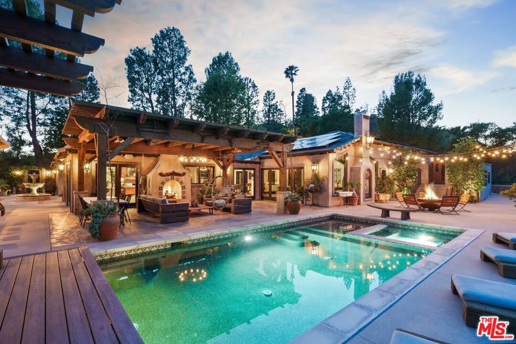 A private retreat in the heart of Orange County's natural splendor, this magnificent estate is set upon 1.2 pristine acres with vistas of the Santiago Oaks Regional Park and mountain range, offering a rare confluence of architecture, nature, and tranquility. With uninterrupted vistas that stretch across the protected canyons and open spaces of Orange County, this bespoke designer residence is a masterclass in understated elegance and intentional design, where every element is curated to harmonize with the surrounding landscape. The home unfolds in a series of warm, textural spaces that merge seamlessly through an open-concept floorplan. The walls of oversized glass doors and windows invite the natural backdrop inside, while an artisan-crafted Koi pond serves as a living centerpiece. The main living areas - kitchen, dining, and lounge - are unified in their sense of flow and airiness, ideal for both quiet moments and refined entertaining. The chef's kitchen features quartz countertops, state of the art stainless steel appliances, Thermador double oven and range, built in coffee/espresso maker, and a large island and breakfast bar. Each of the four bathrooms evokes a bespoke spa retreat, with designer fixtures, tactile finishes, and a dedication to both form and function. Beyond the interiors lies a resort-worthy outdoor sanctuary. A fully equipped outdoor chef's kitchen and entertainment center, vineyard, bocce court, and curated seating vignettes are arrayed around a crystal-clear pool and spa - each feature thoughtfully positioned to capture the natural drama of the canyon beyond. Enjoy the multiple fireplaces and gathering spaces that offer year-round ambiance. The exterior also includes an infrared sauna and outdoor shower. The home includes concrete tile roof and a fully owned solar system that will be transferred to the new owner, as well as a soft water system for the entire home. This is not simply a home - it is a sensorial experience, a retreat for the soul, and a bold architectural statement waiting to be discovered.