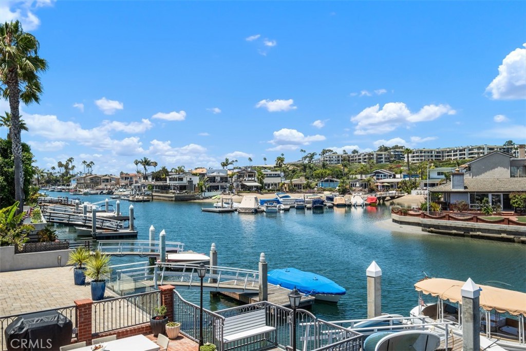 Discover the epitome of coastal elegance with this exquisite bayfront residence on Newport Island, a hidden gem within Newport Beach. This meticulously crafted three-bedroom, three-bathroom home seamlessly blends luxury with the tranquil allure of waterfront living. Ideal for boating enthusiasts, the property features a private dock offering direct access to the bay for sailing or paddleboarding adventures. The expansive open floor plan is enhanced by wall-to-wall windows that frame mesmerizing waterfront vistas, bathing the interior in natural light. The gourmet kitchen boasts stone countertops, premium appliances, and a butcher block peninsula, all overlooking the serene bay waters. The warm and inviting family room, complete with a cozy brick fireplace and panoramic bay views, is perfect for intimate gatherings. An additional first-floor area provides versatile living space, suitable as a children's playroom, home office, or entertainment space. The romantic primary suite serves as a tranquil retreat, featuring a fireplace, vaulted wood-beam ceilings, and breathtaking bay views. Two generously sized secondary bedrooms share access to a spacious covered patio, ideal for enjoying the coastal breeze. Outside, the enchanting bayside patio offers an idyllic setting for sunset soirées, barbecues, or morning coffee with loved ones. Nestled adjacent to the Balboa Peninsula, Newport Island is a serene enclave known for its charming streets and close-knit community. Residents enjoy unparalleled access to some of Southern California's finest surfing beaches and a pedestrian-friendly environment, with boutique shops and restaurants just a leisurely stroll away. This property not only offers a luxurious living experience but also immerses you in the quintessential Newport Beach lifestyle, where every day feels like a retreat.