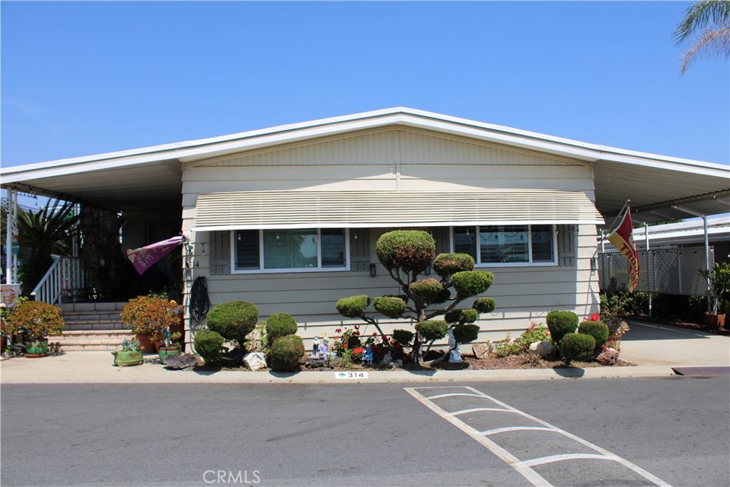Triple-wide manufactured home approximately 1,746 sq. ft. (buyer to verify). Recently remodeled master bathroom. Newer double-pane windows in the living room and master bedroom. Features wood shutters in the living and family rooms. Spacious family room includes a bar with barstools. The kitchen offers a breakfast bar, ample pantry space, and a large additional closet between the kitchen and laundry area for extra storage. The home includes a large linen closet in the primary bathroom. Flooring includes carpet in the living room and bedrooms, neutral vinyl in the family room, and laminate in the kitchen. Composition roof is approximately 9 years old. Appliances are included (washer, dryer, and refrigerator and microwave) all functional. Exterior highlights include a front porch, back patio, block steps in front and back, and two storage sheds. Located in the beautiful and highly sought after Twin Oaks Park in La Verne.