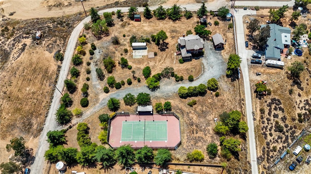 Welcome to this one-of-a-kind Agua Dulce property, where classic Hollywood charm meets expansive views, country serenity, and thoughtfully updated interiors. Set on 2.5 flat, fully fenced and usable acres, this home offers versatility, privacy, and comfort—ideal for those who want room to live, create, and unwind. Inside, the home features 1,844 sq ft of inviting living space, highlighted by a modern, renovated kitchen with updated finishes, and a freshly styled laundry room with new washer and dryer included. The primary suite offers a peaceful retreat, complete with a modern, renovated bathroom featuring a walk-in shower, dual vanity, and clean, contemporary design. Enjoy incredible views out every window, along with outdoor amenities that cater to both relaxation and recreation. The lighted sport court is ideal for tennis, pickleball enthusiasts, or even adding basketball hoops—perfect for those who love outdoor sports and entertaining. A 2-story detached garage offers bonus room or ADU potential, and the entire property is surrounded by secure fencing. Major upgrades include a new roof, HVAC system, and ducting (2019), plus a water storage tank and two on-site wells. Located on a paved road, this property offers rare convenience in a rural setting. Whether you’re drawn by the character, the space, or the endless possibilities, this Agua Dulce gem delivers style, infrastructure, and freedom all in one remarkable property.