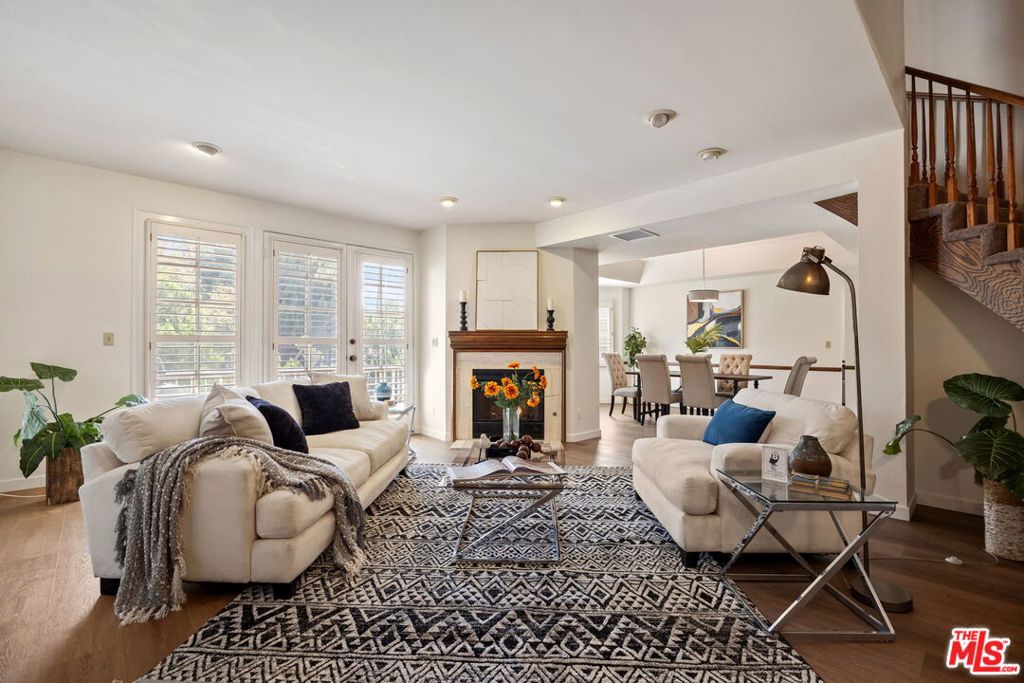 Welcome to this beautifully updated over 2,200 sqft townhome in the heart of Tarzana, offering comfort, style, and convenience in a secure gated community. Set inside a Cape Cod-style community, this residence makes a striking first impression with its charming architectural details and lush landscaping. Inside, you'll find updated interiors with brand-new vinyl flooring that flows seamlessly throughout the main living spaces. The inviting living room features a cozy fireplace, recessed lighting, and a cascading staircase, creating an ideal setting for both everyday living and entertaining. The adjacent dining area is bathed in natural light from the bay windows, while the spacious kitchen offers abundant cabinetry, tile counters, a center island, and a convenient pass-through. A wet bar and powder room on the main level add to the home's functionality. Upstairs, the expansive primary suite serves as a true retreat, complete with a walk-in closet and an ensuite bath featuring dual sinks, a soaking tub, and a separate shower. Two additional bedrooms are generously sized with ample closet space, accompanied by another full bathroom with dual vanities. A versatile bonus room provides the perfect space for a home office, media room, or guest quarters. Additional highlights include plantation shutters, in-unit laundry, and direct access to a private 2-car garage. The well-maintained community offers a tranquil environment while being just minutes from Tarzana's and Encino's best shopping, dining, schools, and freeway access.