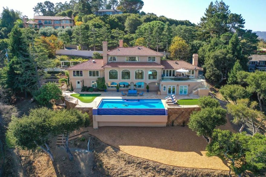 Take advantage of this huge price drop. Motivated seller. This Mediterranean style villa retreat sits atop the foothills of Hillsborough on a private, gated, stunningly-landscaped lot measuring +/- 1.84 acres with 7 bedrooms (including 2 master suites), 5.5 bathrooms, two offices, a theater room, conditioned wine cellar, three-car garage, large infinity pool, outdoor jacuzzi, and indoor infrared sauna.  This home has been beautifully redone to include all your modern-day requirements, including a gourmet kitchen leading to a large patio. Your living and dining rooms have large-span windows with sweeping 180-degree views of downtown San Mateo and the Bay. The outdoor patio, swimming pool and all the bedrooms have spectacular views. A custom infinity edge pool, private putting green and a beautiful temperature-controlled, cave-style wine cellar that holds up to 4,000 bottles add magic to any occasion.  This is not just a home, this is an experience not to be missed.