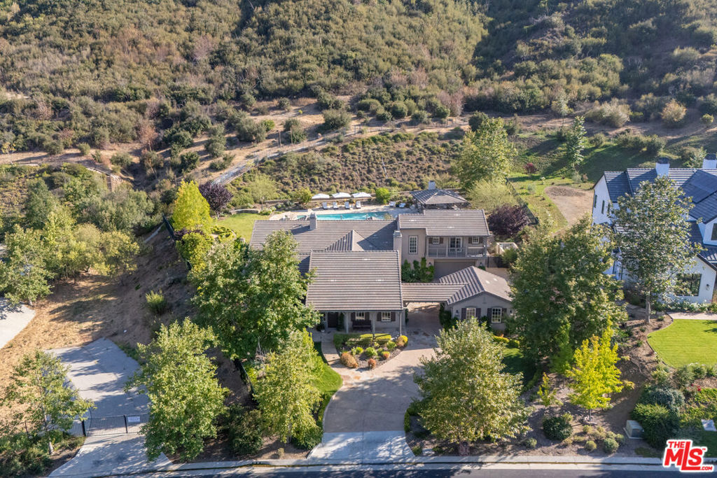 Welcome to a one-of-a-kind retreat, nestled behind private gates in the scenic hills of Agoura, where resort-style living meets timeless elegance. Located in the exclusive Vintage at Hidden Park community, this exquisitely remodeled estate sits on nearly 1.5 acres of beautifully landscaped grounds, offering the perfect blend of luxury, privacy, and natural beauty. The home features four spacious ensuite bedrooms, a thoughtfully designed nursery, and five fully remodeled bathrooms, each appointed with premium finishes and spa-inspired details. A completely renovated gourmet kitchen serves as the heart of the home, boasting top-of-the-line appliances, custom cabinetry, and designer stone countertopsideal for both everyday living and elevated entertaining.The open-concept floor plan is filled with natural light and high ceilings, creating a seamless flow between the expansive living and dining areas. The luxurious primary suite offers a peaceful sanctuary, complete with a spa-like bathroom and dual walk-in closets, providing both functionality and indulgence. For wellness enthusiasts, the home includes a private gym and sauna, creating a true at-home retreat.Designed with health and wellness in mind, this home features a whole-house water filtration system and non-toxic paint products throughout, ensuring a cleaner, healthier indoor environment for you and your loved ones.Step outside into your own resort-style backyard, where a sparkling pool is surrounded by lush landscaping, mature trees, and a tranquil al fresco dining area perfect for outdoor entertaining or quiet evenings under the stars. Additional features include a 4-car garage, ample driveway parking, and access to nearby hiking trails and open space preserves. All of this, just minutes from the iconic beaches of Malibu, offering the best of both hillside privacy and coastal lifestyle. This move-in ready estate has been meticulously upgraded and styled to perfection an exceptional opportunity to own a turnkey luxury home on nearly 1.5 acres in one of Agoura's most desirable gated communities.