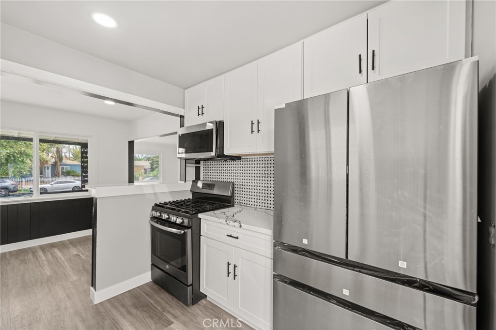 Welcome to this beautifully updated 3-bedroom, 1-bathroom home offering 908 sq ft of comfortable living space on a spacious 4,908 sq ft lot — perfect for a family! Designed with modern touches and family-friendly functionality in mind, the home features a fresh monochromatic color scheme accented by bold red entry doors and sleek black hardware throughout.
Inside, you’ll find brand-new vinyl flooring, fresh paint, and recessed lighting that creates a warm and welcoming feel. The formal dining room with a large window is perfect for family meals or game nights while the cozy front porch invites you to relax and enjoy your new neighborhood.
The remodeled kitchen is a true highlight with all-new cabinets, countertops, backsplash, and stainless steel appliances with direct access to the backyard making it ideal for playtime or weekend BBQs. The renovated bathroom includes a new vanity, mirror, walk-in shower, and upgraded plumbing fixtures.
A long driveway with a carport leads to a gated backyard and detached two-car garage, offering plenty of room for parking, storage, or future play areas. Conveniently located near the 105 and 710 freeways, this home combines modern style with everyday comfort and easy access to schools, parks, and all that Lynwood has to offer!