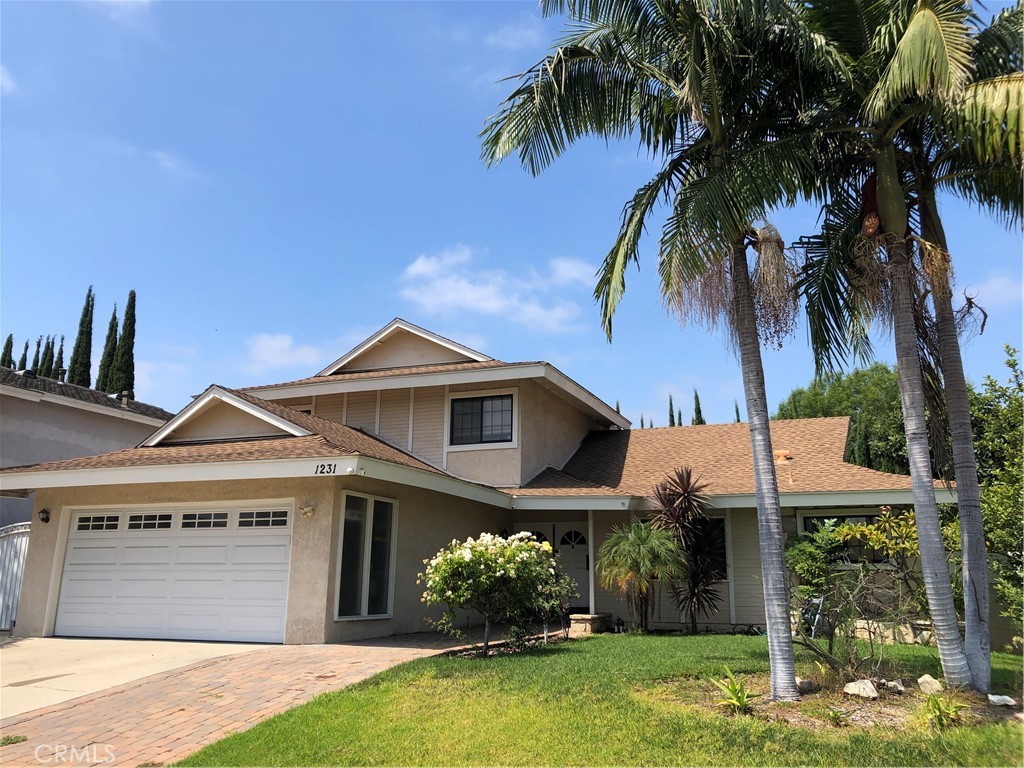 Welcome to this spacious 4 bedroom, 3 bathroom home in one of the most desirable neighborhoods in La Habra. The large living room features a cozy fireplace, creating a welcoming atmosphere and offering direct access to the private backyard. The kitchen is updated with corian counters, stainless steel appliances, and dark wood cabinets. This home has 2 master bedrooms. The main floor master bedroom with adjoining bathroom provides convenience and accessibility. A second full bathroom on the main floor serves both guests and family. Upstairs there is a second master bedroom plus 2 other large bedrooms and a full bath. Recent upgrades include new flooring, plumbing, privacy fence, and contemporary light fixtures. The large private backyard is shaded by mature trees, and a covered patio offers a space for outdoor dining and entertaining. This home provides generous living space with modern amenities and practical features. Conveniently located near top-rated schools, supermarkets, restaurants, entertainment, parks, and freeway access.