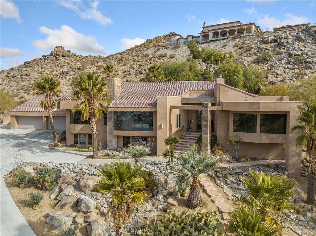 APPLE VALLEY - ESCAPE TO DESERT MODERN LUXURY. Experience the epitome of desert living in this breathtaking 4,000 SF M/L one of a kind Home. Designed for both elegant entertaining and comfortable family living, this exceptional home offers a seamless blend of sophisticated style and the tranquility of the surrounding landscape. Step inside and be captivated by grand living spaces. A formal living room boasts a focal point fireplace and oversized windows framing panoramic views. The adjacent formal dining room provides an elegant space for gatherings. Unleash your inner chef in the gourmet kitchen; custom cabinets; storage, and top-of-the line Viking appliances. The Breakfast nook offers a cozy spot for morning coffee. Relax and recharge in the family room, anchored by a warm wood-burning stove. Retreat to the expansive master bedroom suite, complete with a large spa-like bath featuring a separate shower and his-and-hers custom walk in closets. Large laundry room with storage. Two additional bedrooms on the lower level with an en-suite bath, provide ample space for family and guests. Step outside, just off the family room, to your own private oasis, featuring a sparkling pool and cascading waterfall. A wind and sun-protected covered patio provides the perfect setting for outdoor dining and entertaining year-round. A four car, oversized garage, with additional loft storage is a plus! This exceptional home is ideally situated for easy access to freeway connections. Enjoy the convenience of nearby shopping, dining and entertainment options. Also close by to the hospital and other medical facilities. With its prime location, upgrades and one-of-a kind views, this Home is exceptional. Don't miss this rare opportunity to own a piece of desert paradise!