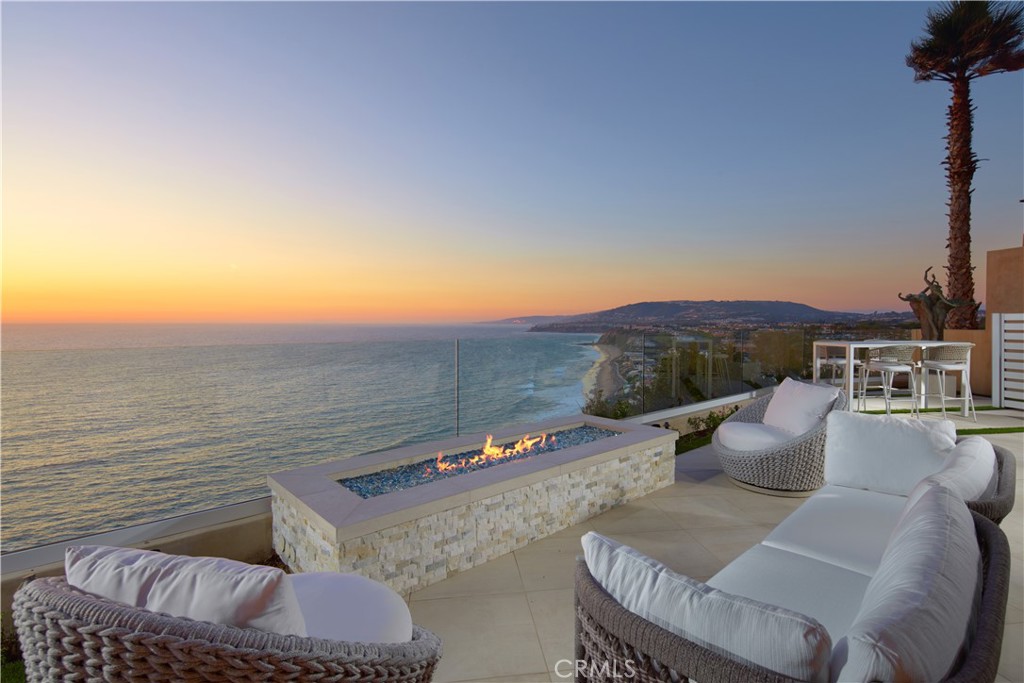 OCEANFRONT WITH UNIQUE 7-CAR GARAGE. Perched atop Dana Point's historic Headlands, Residence B immerses you in unmatched ocean vistas from San Diego to Palos Verdes, blending modern luxuries with coastal elegance. This home stands apart due to a major remodel in 2017 and subsequent upgrades in 2021 and 2023, setting a new benchmark in coastal luxury living. As the largest floorplan in the community, this recently remodeled home boasts today's most desired features, offering bespoke living at the Pacific Ocean's edge. The unparalleled views span from San Diego, across crashing waves and sandy shores, to Catalina and north to Palos Verdes. This approximately 4,537 SF home includes three en-suite bedrooms and three-and-a-half baths. Upon entering through the gated entrance and double doors, you're greeted by a breathtaking foyer with an immediate ocean view, a Quintus chandelier, and a J.H. Minasian silk rug. Many hand-picked furnishings, included in the residence, are from top designers such as Roche Bobois, Cantoni, Holly Hunt, Shine by Sho, Ziething, and Jonathan Franc. The ocean-view dining room is accentuated by a custom glass wall panel, while the great room showcases vast windows, a linear fireplace, and a balcony with beach views. The state-of-the-art kitchen shines with beautiful quartz countertops, a sizable island, a walk-in pantry, and built-in appliances from Sub-Zero, Wolf, and Miele, including a coffee station, steam oven, and microwave/convection oven. Just steps above the main kitchen, discover a butler's pantry and a glass-enclosed, temperature-controlled wine room with a 567-bottle capacity. On the other wing, a chic home theater boasts over $156,000 in top-tier AV equipment and a built-in concessions cabinet. The primary suite offers mesmerizing ocean views, Thomas Lavin wall coverings, a standalone tub, built-in vanity, quartz countertops, and a spacious walk-in closet with custom California Closets built-ins. A new glass and steel staircase descends to the lower level, which invites relaxation in the family room, workouts in the gym that features an attached full bath, or outdoor enjoyment in the fully renovated backyard with an above-ground spa. The residence concludes with a seven-car custom-style garage, private with a separate garage door and access to the lower level.