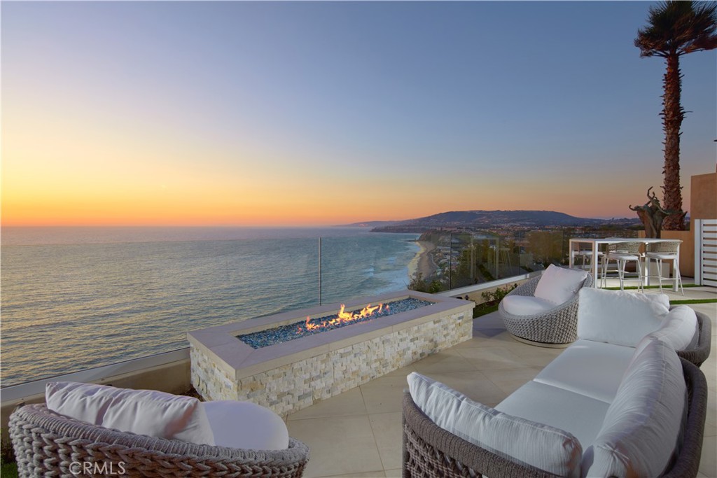 Perched atop Dana Point's historic Headlands, Residence B immerses you in unmatched ocean vistas from San Diego to Palos Verdes, blending modern luxuries with coastal elegance. This home stands apart due to a major remodel in 2017 and subsequent upgrades in 2021 and 2023, setting a new benchmark in coastal luxury living. As the largest floorplan in the community, this recently remodeled home boasts today's most desired features, offering bespoke living at the Pacific Ocean's edge. The unparalleled views span from San Diego, across crashing waves and sandy shores, to Catalina and north to Palos Verdes. This approximately 4,537 SF home includes three en-suite bedrooms and three-and-a-half baths. Upon entering through the gated entrance and double doors, you're greeted by a breathtaking foyer with an immediate ocean view, a Quintus chandelier, and a J.H. Minasian silk rug. Many hand-picked furnishings, included in the residence, are from top designers such as Roche Bobois, Cantoni, Holly Hunt, Shine by Sho, Ziething, and Jonathan Franc. The ocean-view dining room is accentuated by a custom glass wall panel, while the great room showcases vast windows, a linear fireplace, and a balcony with beach views. The state-of-the-art kitchen shines with beautiful quartz countertops, a sizable island, a walk-in pantry, and built-in appliances from Sub-Zero, Wolf, and Miele, including a coffee station, steam oven, and microwave/convection oven. Just steps above the main kitchen, discover a butler's pantry and a glass-enclosed, temperature-controlled wine room with a 567-bottle capacity. On the other wing, a chic home theater boasts over $156,000 in top-tier AV equipment and a built-in concessions cabinet. The primary suite offers mesmerizing ocean views, Thomas Lavin wall coverings, a standalone tub, built-in vanity, quartz countertops, and a spacious walk-in closet with custom California Closets built-ins. A new glass and steel staircase descends to the lower level, which invites relaxation in the family room, workouts in the gym that features an attached full bath, or outdoor enjoyment in the fully renovated backyard with an above-ground spa. The residence concludes with a seven-car custom-style garage, private with a separate garage door and access to the lower level.