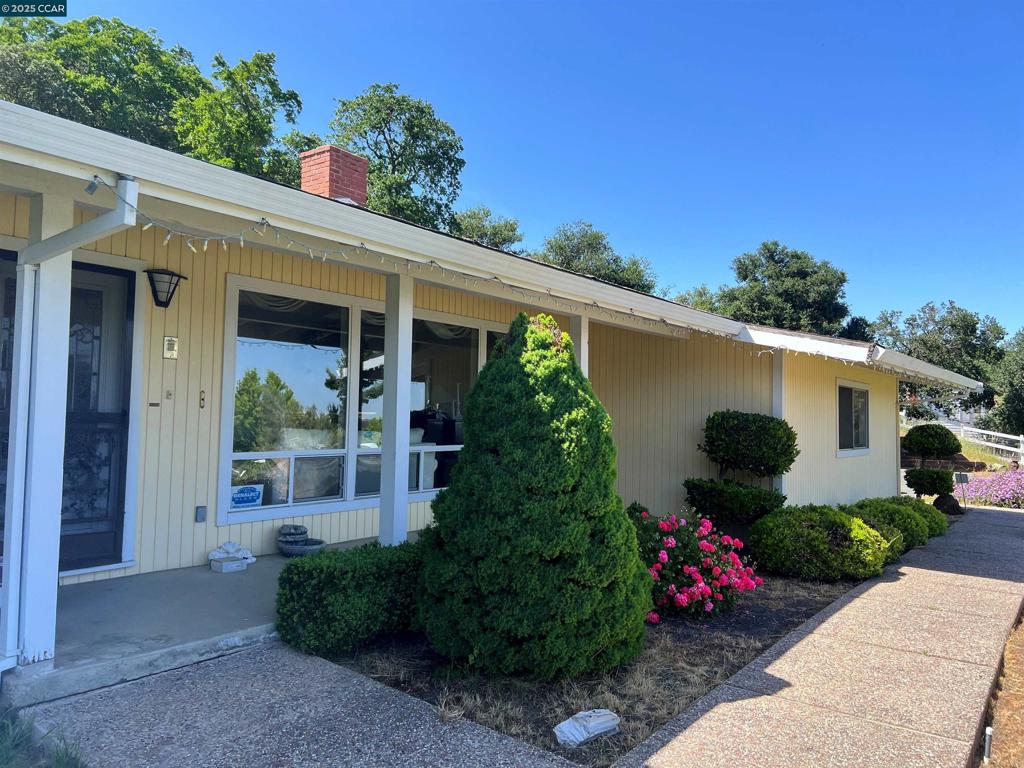 This single-family home, built in 1963, offers 4 bedrooms and 3 bathrooms across 2,533 square feet of living space. The property sits on a 0.96-acre lot and features forced air heating, central cooling, and a fireplace. The home has an attached garage with two parking spaces. Additionaly, the property inludes electrical hook-up for a motor home. Located in the desirable Muir Oaks neighborhood, this home boasts breathtaking views of the hills surrounding Mt. Diablo, providing a picturesque and peaceful setting. Nestled adjacent to the California Riding and Hiking Trail, this property offers easy access to scenic outdoor recreation, making it ideal for nature lovers and equestrian enthusiasts. Additionally, the property features a dedicated arena for horses, perfect for riding and training. The upstairs primary bedroom is a standout feature, offering a private deck with stunning views, making it a perfect retreat for relaxation and enjoying the surrounding landscape. Bathroom count different than public records. Property being sold in its present "as-is" condition.