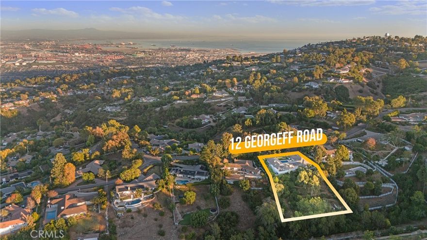 Nestled in the upper reaches of the prestigious gated community of Rolling Hills, 12 Georgeff Road offers unparalleled city and lush canyon views in addition to the ocean view in the distance. This single-story residence is a private retreat, hidden behind mature pine trees and a verdant privacy wall of vines.

The centerpiece of the outdoor oasis is a sparkling pool and spacious courtyard, perfect for relaxing or entertaining. A trellis-shaded outdoor kitchen sits elegantly in the corner, creating an idyllic space for al fresco dining.

Inside, the home welcomes you with a sophisticated living room featuring a white stone fireplace and a spacious dining room framed by floor-length picture windows that capture breathtaking city views. The remodeled kitchen boasts Viking appliances, granite countertops, and a cozy breakfast area with a view, seamlessly connecting to a family room with a large balcony overlooking the canyon and city below.

This thoughtfully designed home features seagrass carpet and dual-pane windows throughout. All five bedrooms are situated on the same floor, each with its own en-suite bathroom, ensuring comfort and privacy for all. The primary suite includes a spacious walk-in closet and a luxurious bathroom illuminated by a skylight.

Beyond the home, a paved hillside road leads to a flat grassy area with a playground, a secluded haven for relaxation or play. Beneath the house lies a large unfinished basement, offering endless possibilities for a gym, art studio, or additional storage.

This extraordinary property is a rare find in Rolling Hills, combining luxury, tranquility, and panoramic views. It’s ready for a new owner to call it home. Don’t miss your chance to own this gem!