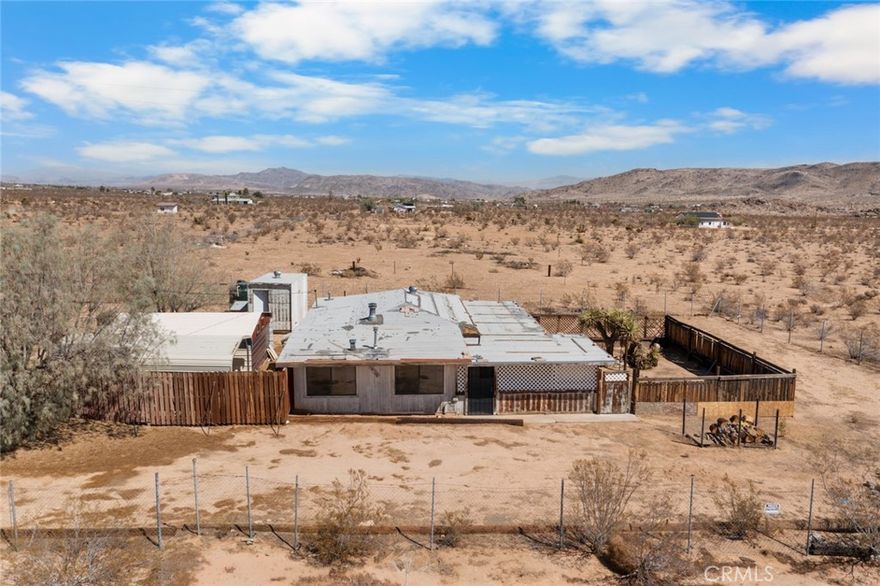 The fixer with tons of potential you've been looking for in Landers. Covered carport as well as metal garage. Fully fenced, cross-fenced and gated. Private fenced side yard anchored by native Mojave yucca. The property offers privacy and space with amazing desert and mountain views. Home is on hauled water but a water meter can easily be added through the Bighorn Desert View Water District. A new septic tank was installed in 2023. Roof is past end of life and will need a new roof. Buyers to do own their own due diligence regarding permits and codes. No repairs will be made. Cash Only.