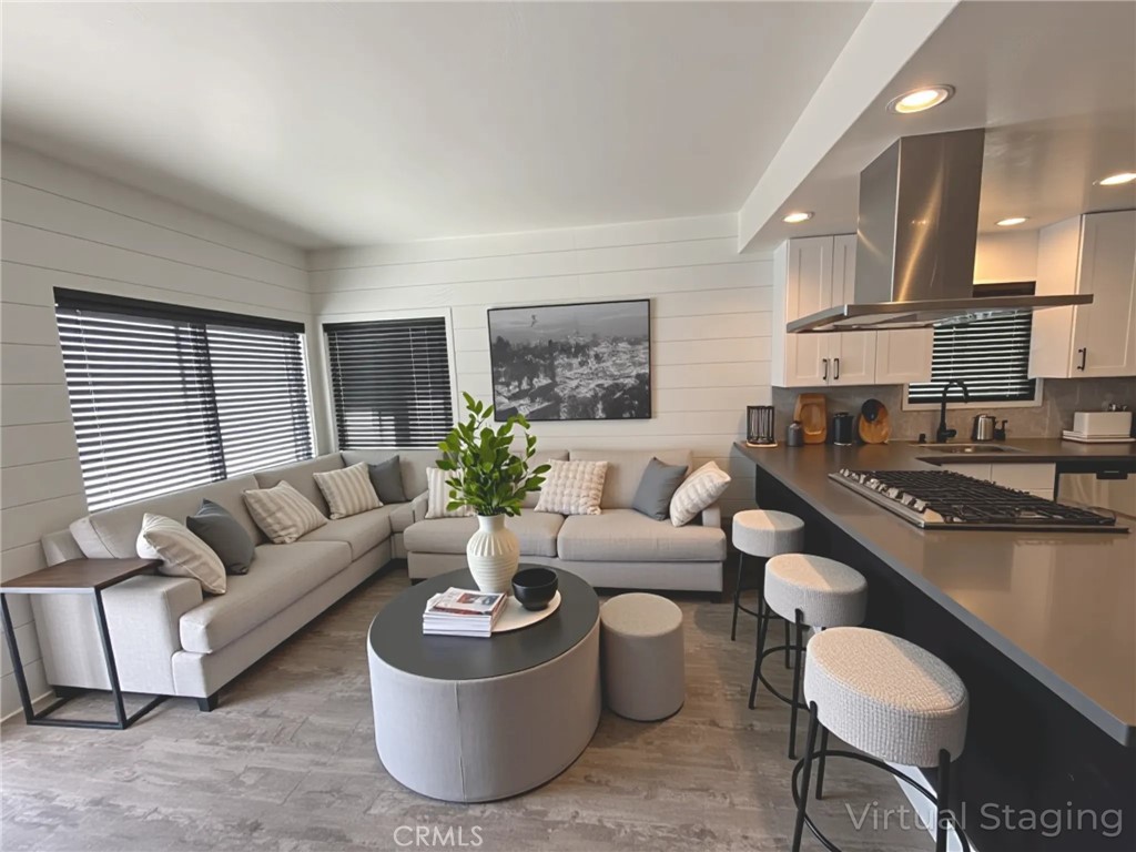 Modern Coastal Duplex with bonus studio penthouse in Lido Marina Village, an exceptional modern coastal located in the heart of Newport Beach’s exclusive Lido Marina Village. Just moments from the marina, beach, and renowned hotspots like Nobu, Mayor’s Table, and Lido House. Meticulously upgraded throughout, this duplex features approximately 2,700 square feet of living space, each unit with private entry and thoughtfully curated interiors designed for comfort, function, and style. The upstairs unit offers 3 bedrooms and 2 bathrooms, highlighted by vaulted ceilings and a large private balcony ideal for entertaining or sunset views. The main-level unit features 2 bedrooms and 2 bathrooms with an open-concept living area and fireplace. The bonus studio unit is a charming studio with a private entrance and full bathroom, perfect for rental or extended guest stays. Each unit boasts a gourmet kitchen outfitted with premium stainless steel appliances, custom cabinetry, and sleek quartz countertops. Additional upgrades include wide-plank wood flooring, spa-inspired bathrooms, and elegant designer finishes throughout. One of the most valuable features of this property is the inclusion of three separate utility meters - for each unit. This setup maximizes rental efficiency, reduces landlord overhead, and offers flexibility for multi-tenant use. The property also offers four parking spaces (including a 2-car garage and 2-car carport), along with peek-a-boo ocean views. Whether you're seeking a luxury beach residence with supplemental income, a family compound, or a high-performing investment, 410 Clubhouse Avenue delivers versatility, elegance, and value in one of the most coveted coastal markets in Southern California.