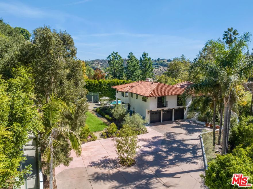 Welcome to 7651 Willow Glen, a sprawling half-acre compound nestled in the prestigious celebrity enclave of Willow Glen Estates. Completely reimagined in 2023, this former Championship Tennis Court estate offers endless possibilities, including RTI-approved plans for a two-story ADU or the option to recreate the private tennis court on the expansive flat grass pad. Inside, this designer-renovated home by Newfield Design Inc. features striking interiors adorned with handcrafted tile, Taj Mahal quartzite surfaces, and top-of-the-line WOLF appliances. The main level boasts a formal living room with a cozy fireplace, and a spectacular great room that seamlessly connects a warm family area, an elegant dining space, and a chef-worthy gourmet kitchen. Wall-to-wall sliding glass doors flood the space with natural light and open effortlessly to an expansive outdoor living area. This level also includes a luxurious 7.1 projection surround sound home theater, a guest suite currently styled as a home office, and a chic powder room. Upstairs, discover two spacious guest bedrooms and a lavish primary suite featuring a private sitting area with fireplace, a spa-inspired steam shower bathroom, and a custom oak walk-in closet. The beautifully landscaped grounds offer a large saltwater pool and spa, a high-end Viking outdoor kitchen with a firepit for entertaining, and an impressive motor court with parking for over 10 vehicles.